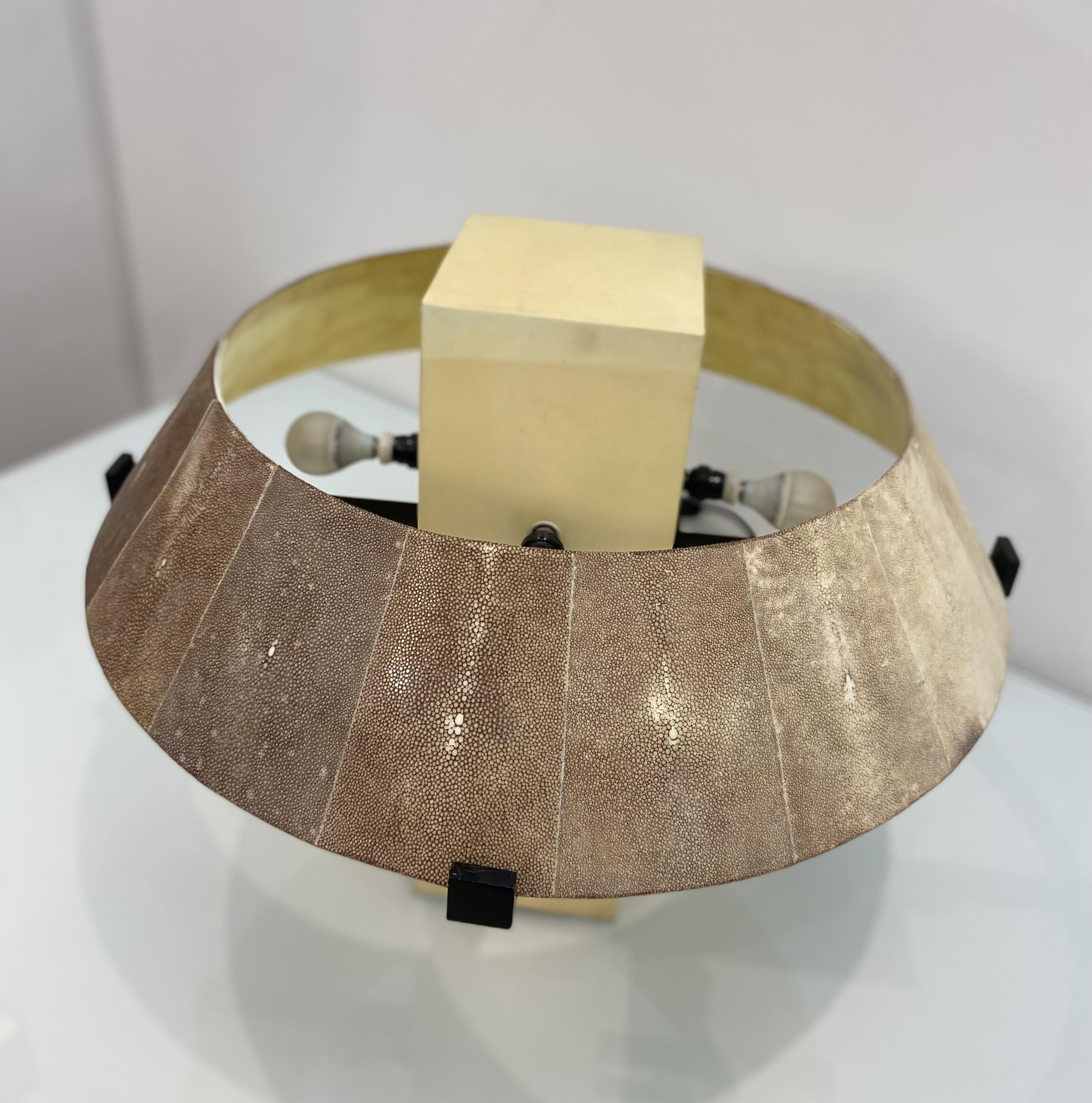 The 'Geo' table lamp by lighting company Alexander Lamont is a unique shaped contemporary piece. With an architectural form, it mixes materials that create a visual interest. 

Featuring an ivory parchment column it has a natural brown coloured