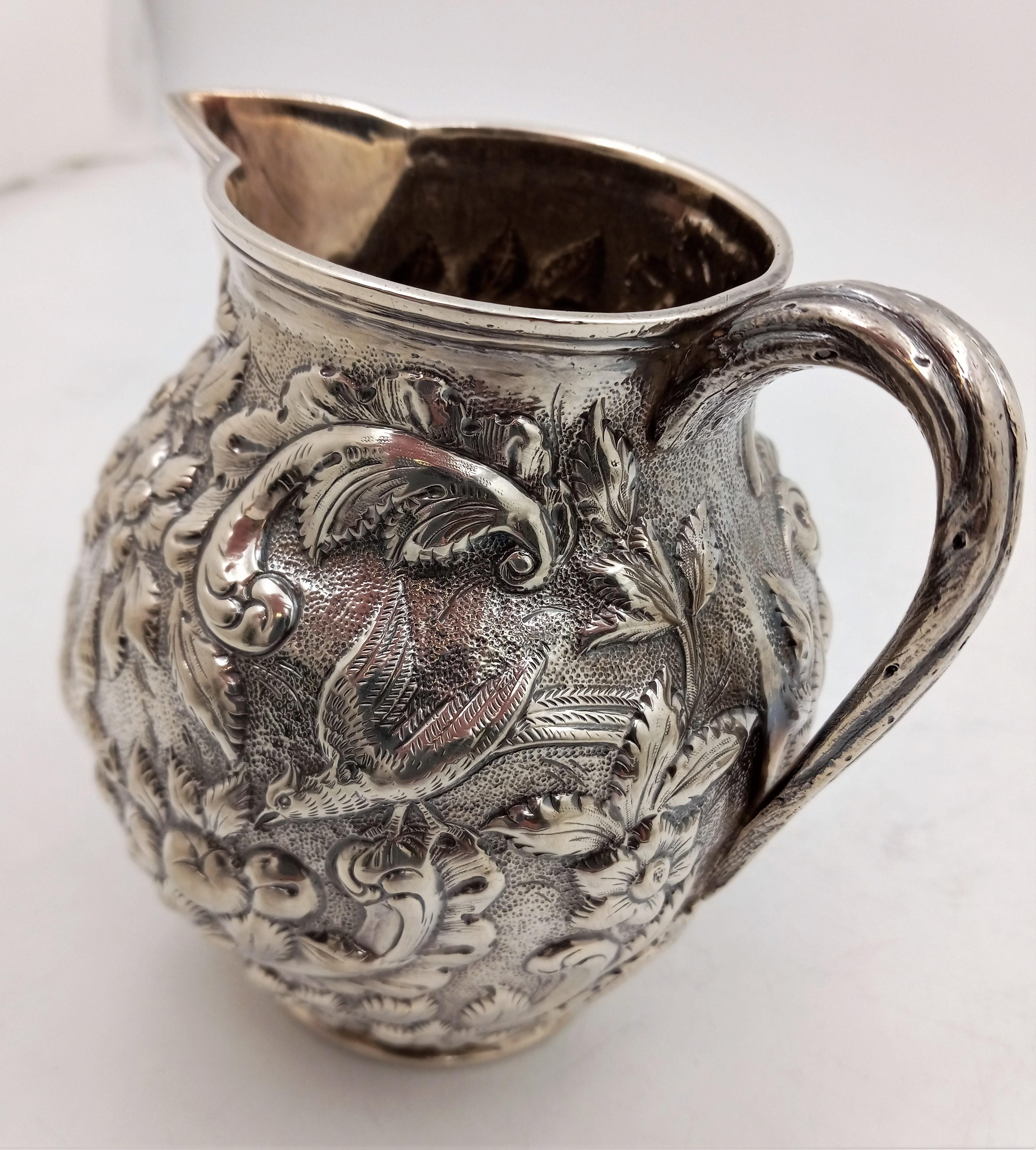 Geo. W. Webb & Co. hand-chased coin silver Aesthetic repousse pitcher, circa 1875--exquisitely detailed with flowers, birds, and fruits with a vined handle. This pitcher stands at 6
