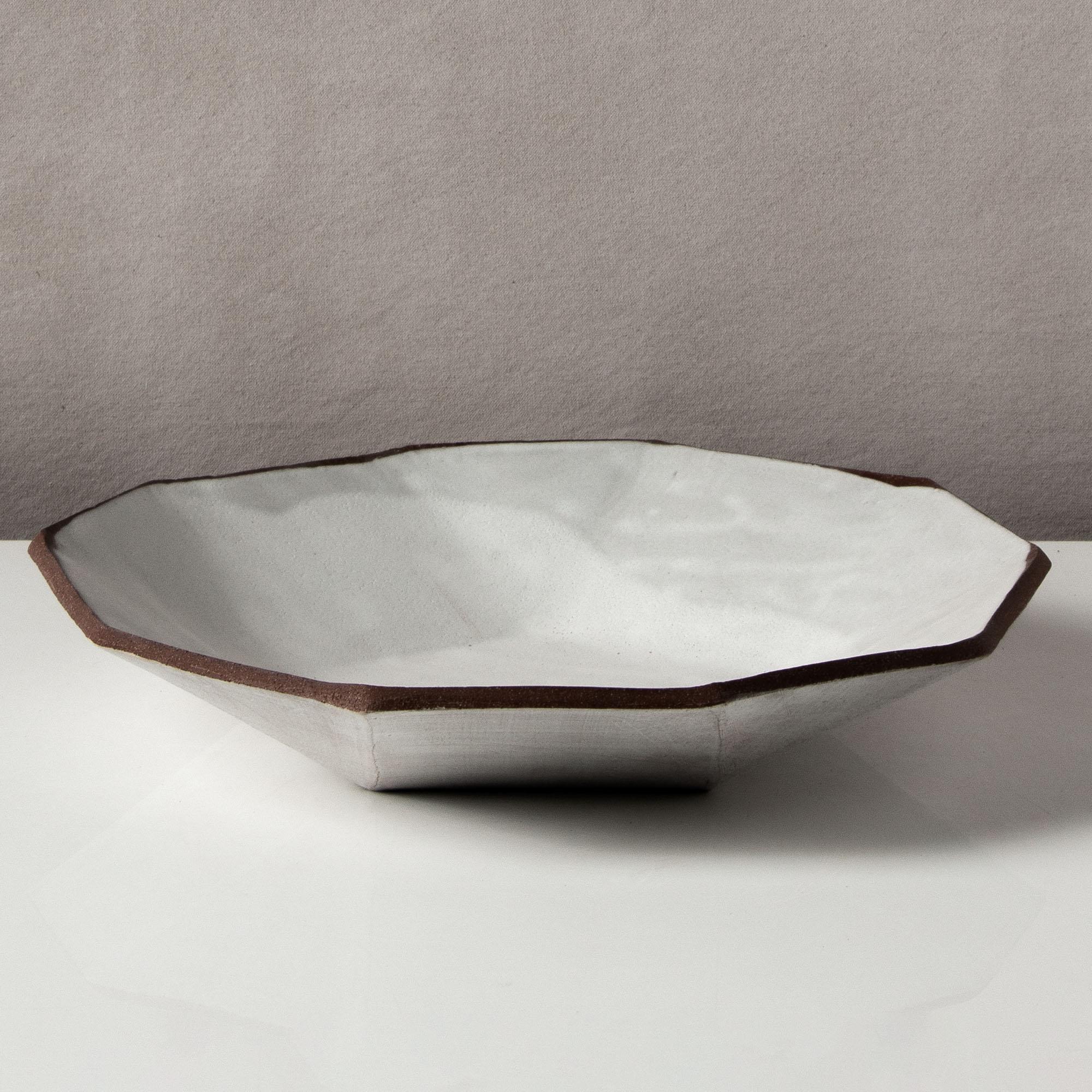 This shallow ceramic bowl combines clean geometric lines with the warmth and individuality inherent in handmade work; it's the perfect statement for a coffee table or sideboard. Each dish is assembled individually from flat sheets of a rich