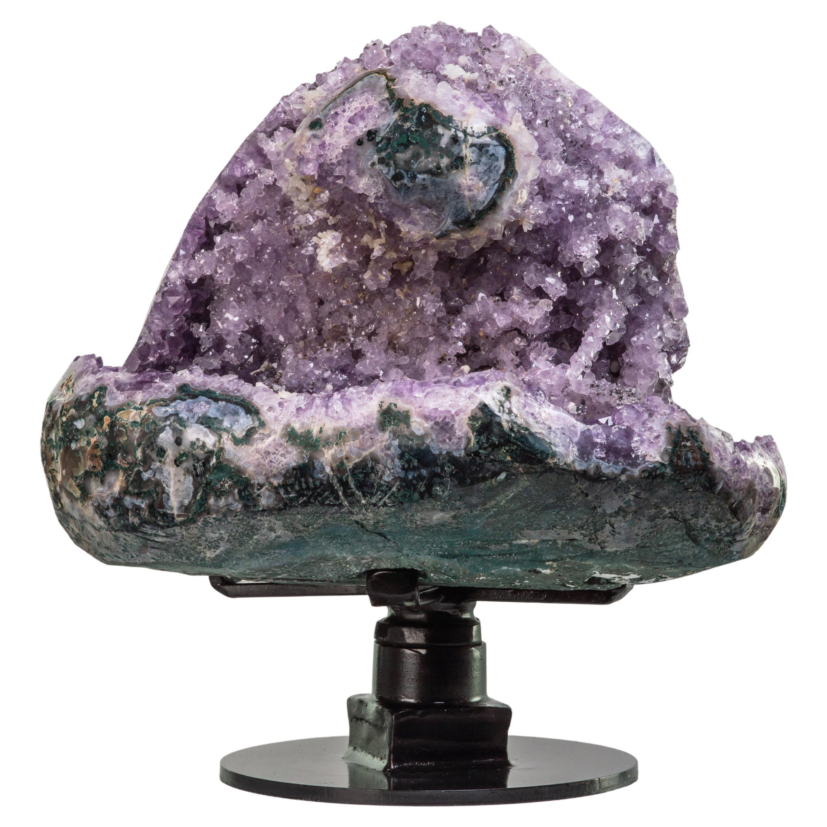 From the “heart” of a large geode, this specimen shows various crystal
formations of note. The multi-windowed piece shows amethyst in typical
peaked form as well as stellate white quartz formations and orange druze
from the other side. The piece