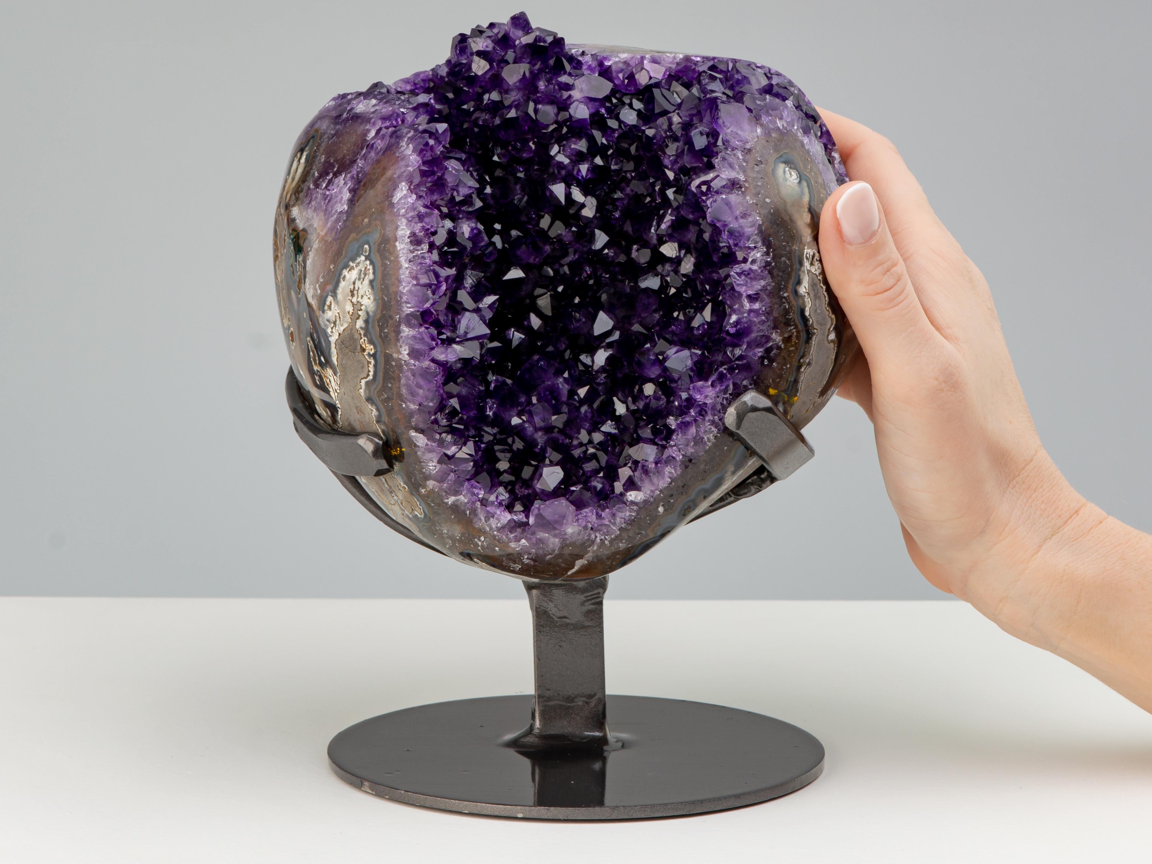 A stunning spherical shaped geode of a deep purple amethyst. The piece is of a wonderful example of a three dimensional geode with particularly thick agate border, revealing grey agate jasper and white quartz. The multicoloured frame intensifies the
