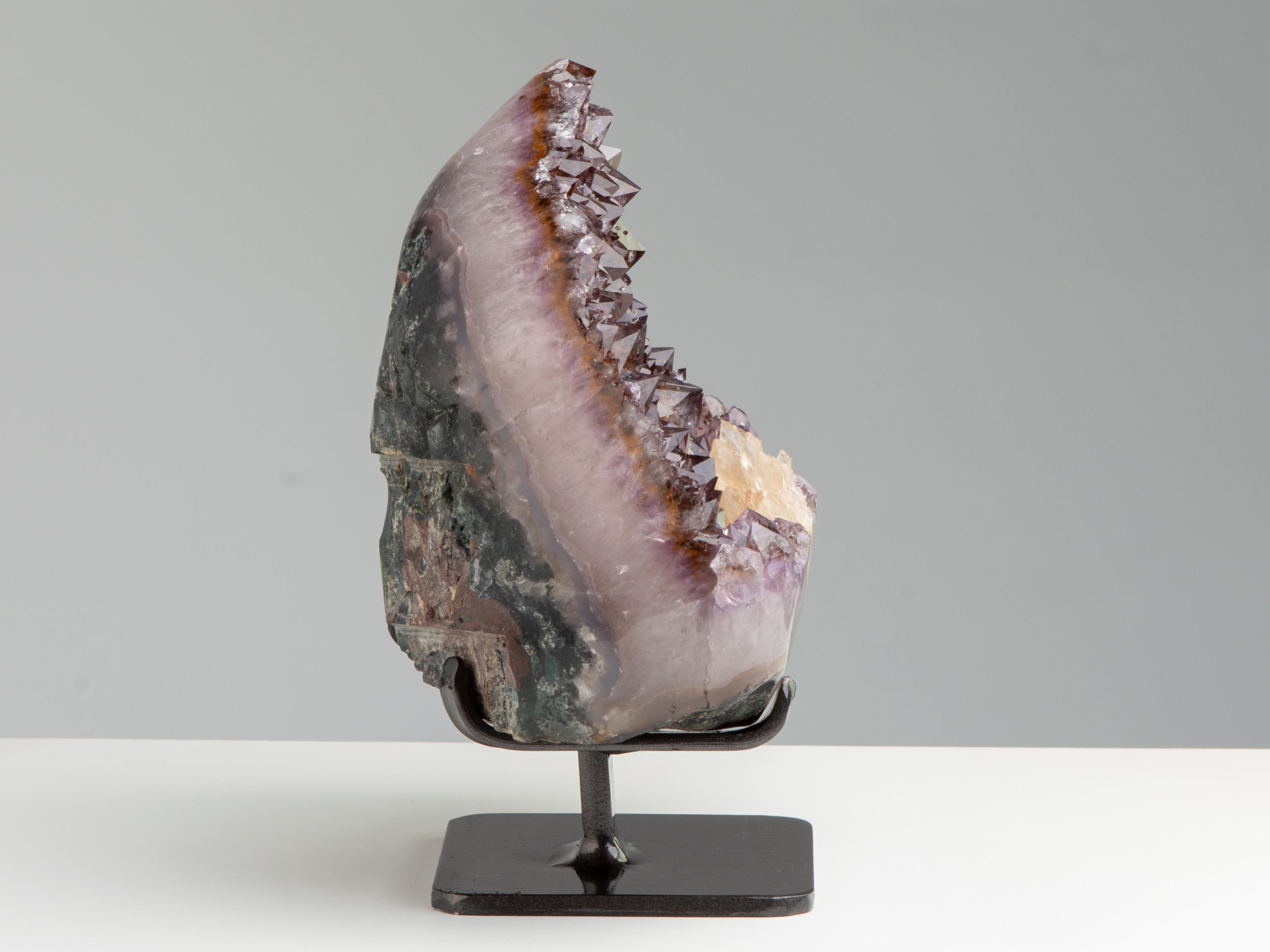 Questo gradevole geode aperto contiene un letto di ametista marrone-arancione
quarzo di dimensioni moderate con una rosetta frontale di diversi piccoli cristalli di calcite.
I bordi sono stati lucidati.

Questo pezzo è stato acquistato in modo