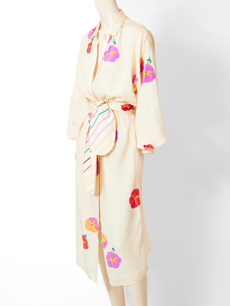Geoffrey Beene crinkled silk, ivory tone, dress, having an Asian inspired, floating, floral pattern. Dress is midi length, buttons down the front with pearl buttons, having a small satin collar and raglan, long sleeves. There is a matching wide self