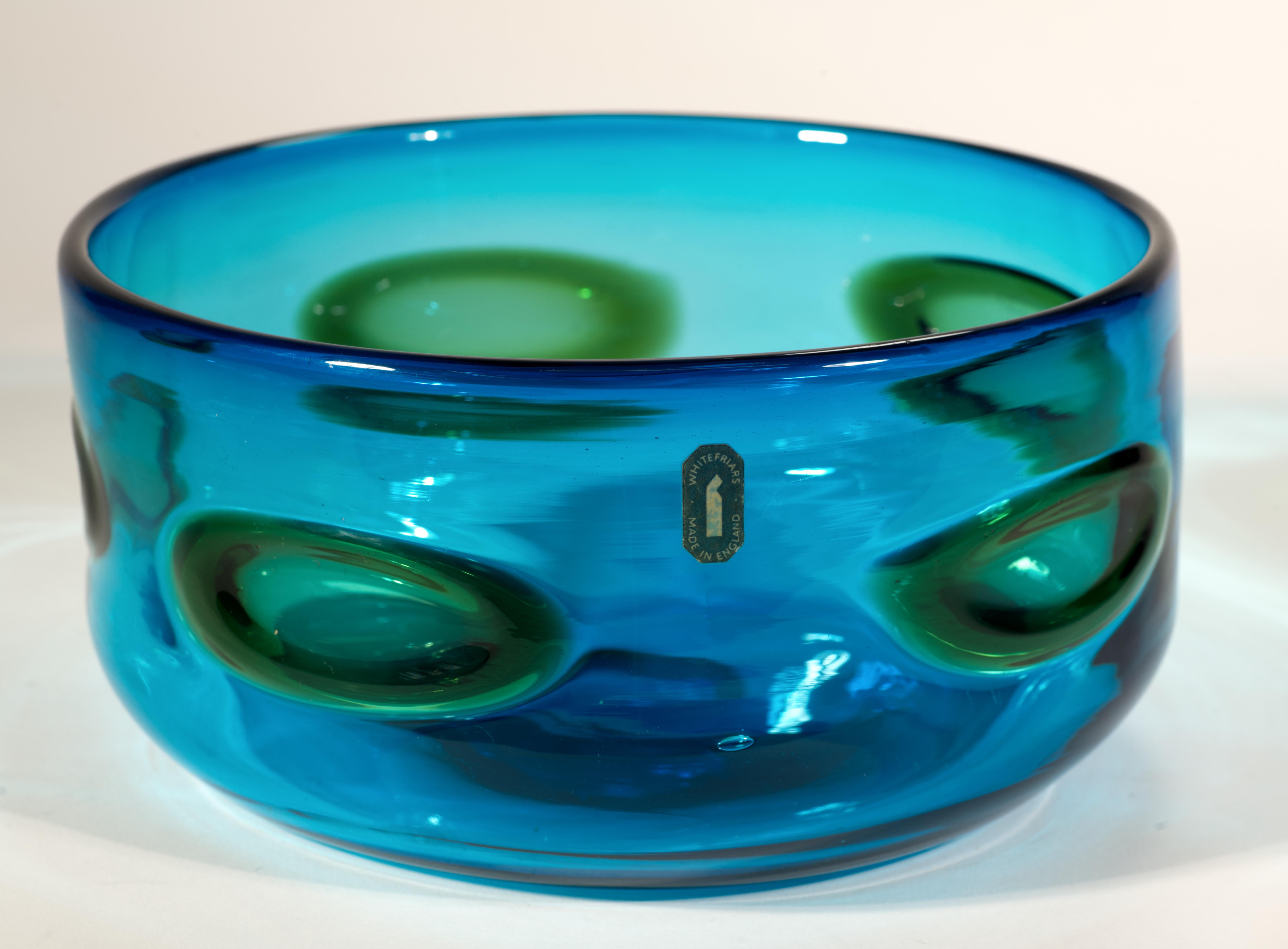  Vintage Midcentury Modern studio art glass centerpiece bowl features textured oval green glass spots on kingfisher blue glass background. It is listed on Whitefriars website as Deep Bowl with Applied Colored Spots #9710, designed in 1969 by