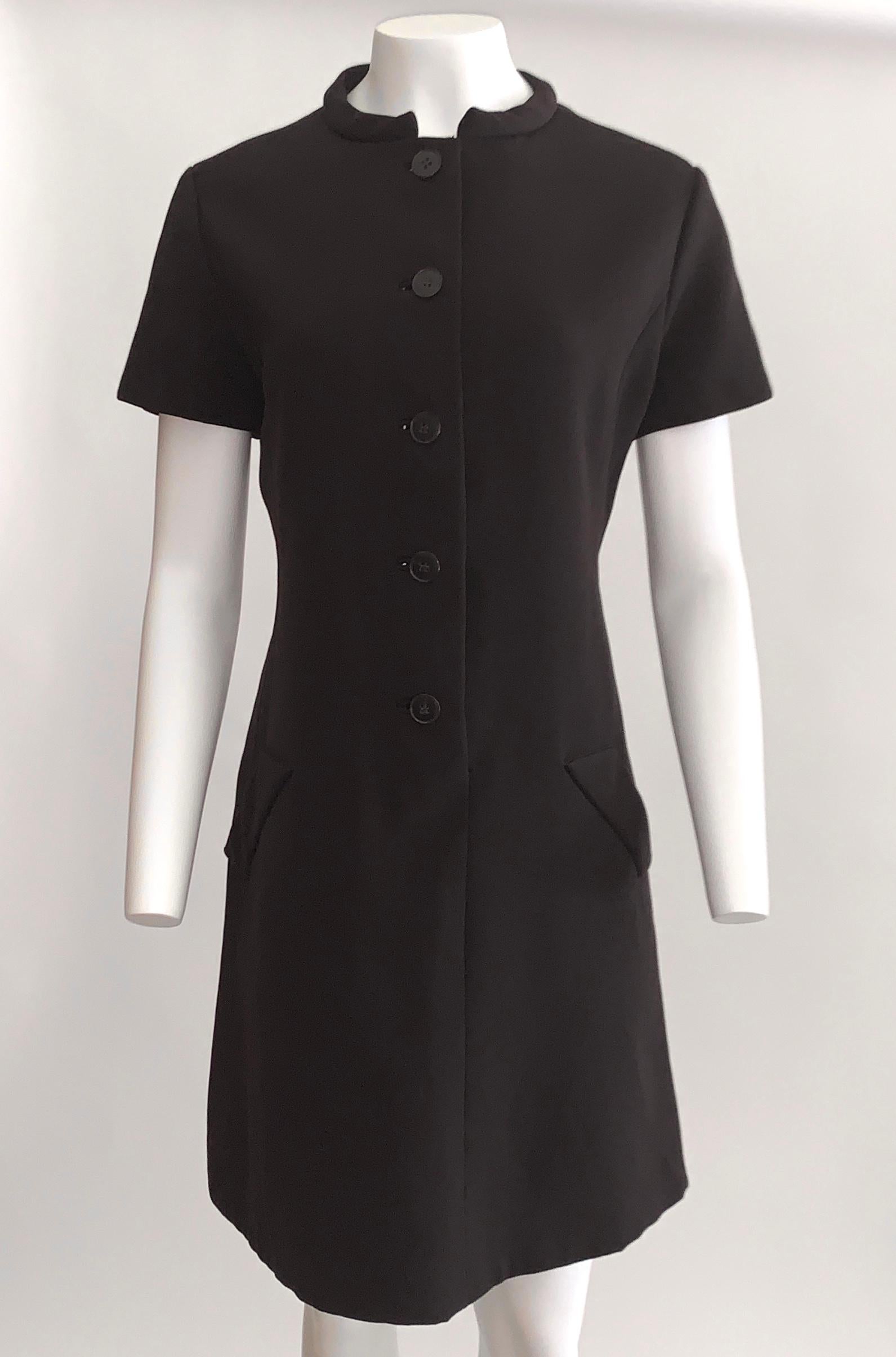 Geoffrey Beene vintage 1960s short sleeve dress with dark plastic tortoiseshell buttons . Faux front pocket detail. Front button closure.

No content label, feels like wool.
Fully lined in a silky fabric. 

No size label. Best fits a size L, see