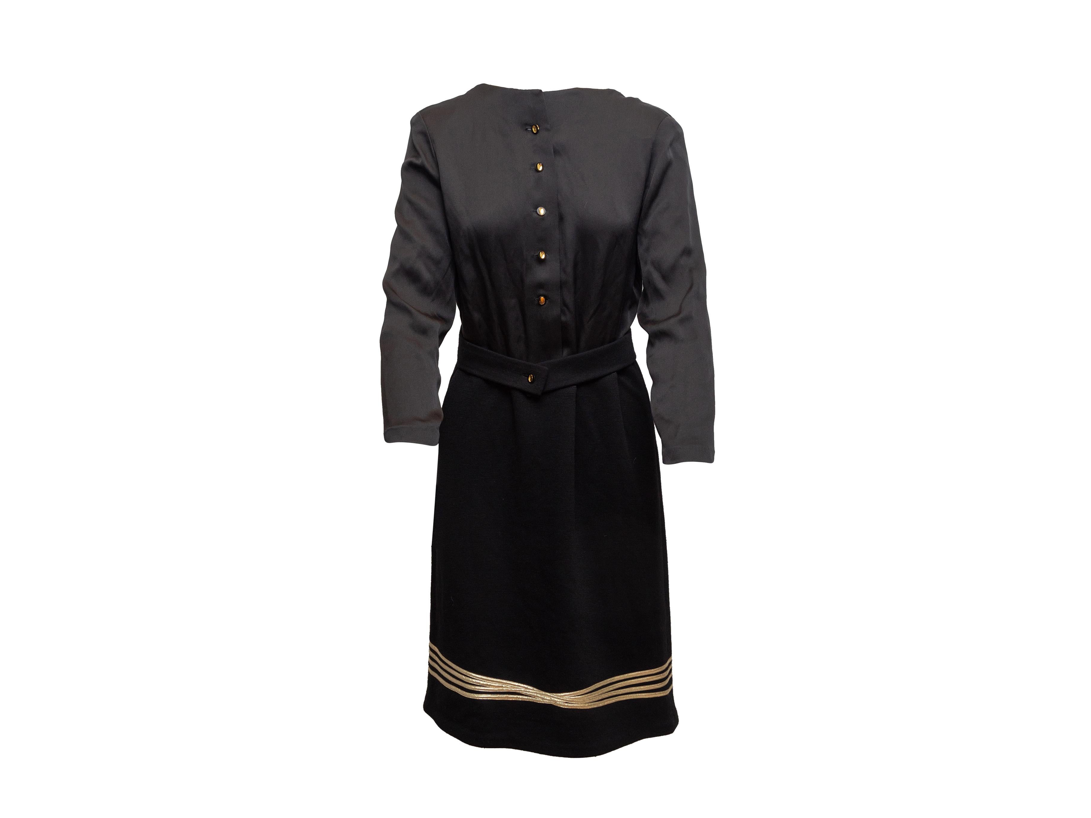 Product details: Vintage black and gold long sleeve dress by Geoffrey Beene. Crew neck. Belt accent at waist. Button closures at front. 36