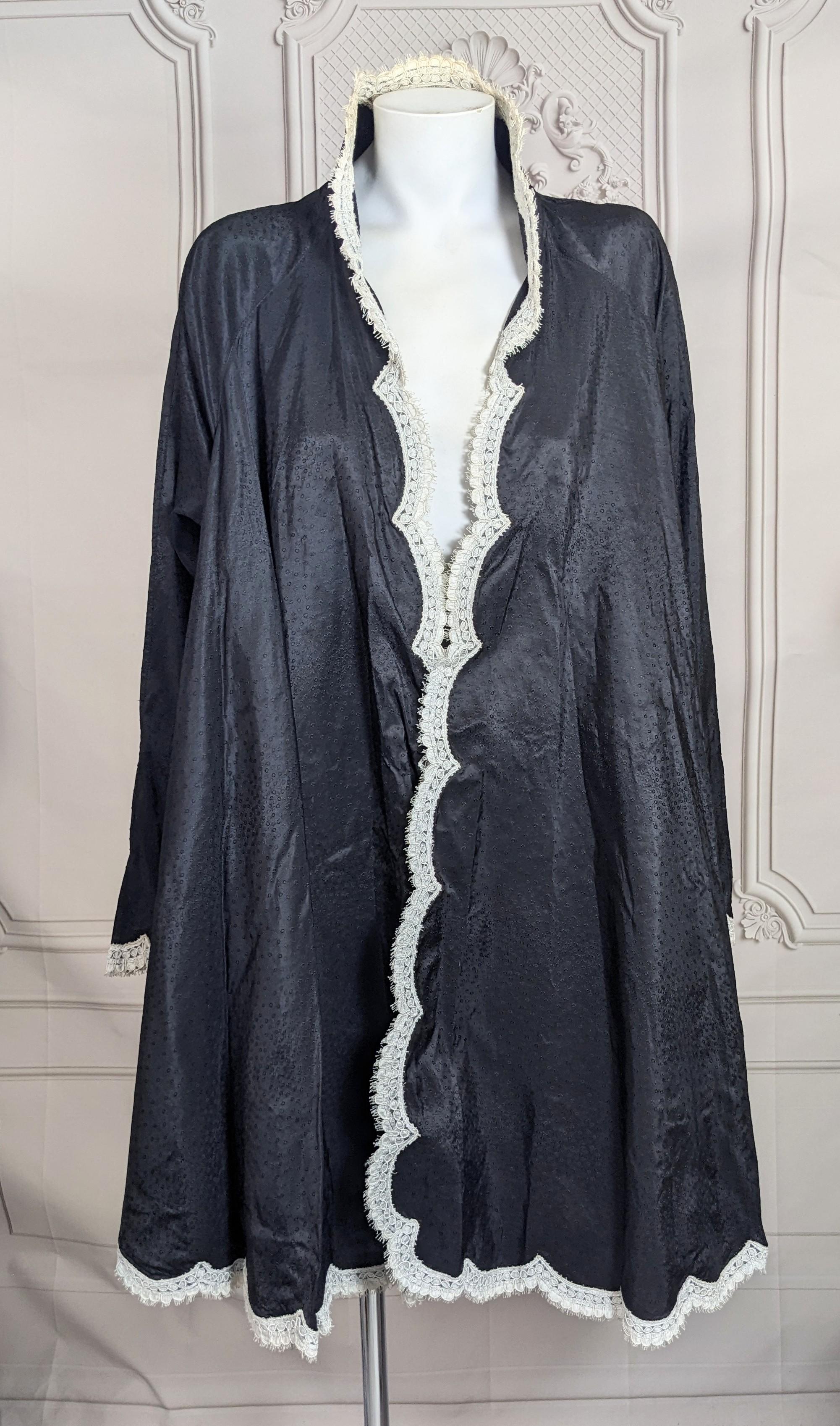 Eleganza di Geoffrey Beene: giacca swing in taffetà di seta jacquard nera con elaborato bordo in pizzo smerlato. Ottimo come copricostume elegante o come abito con cintura. Taglio drammatico a cerchio intero in taffetà con maniche dolman rifinite in