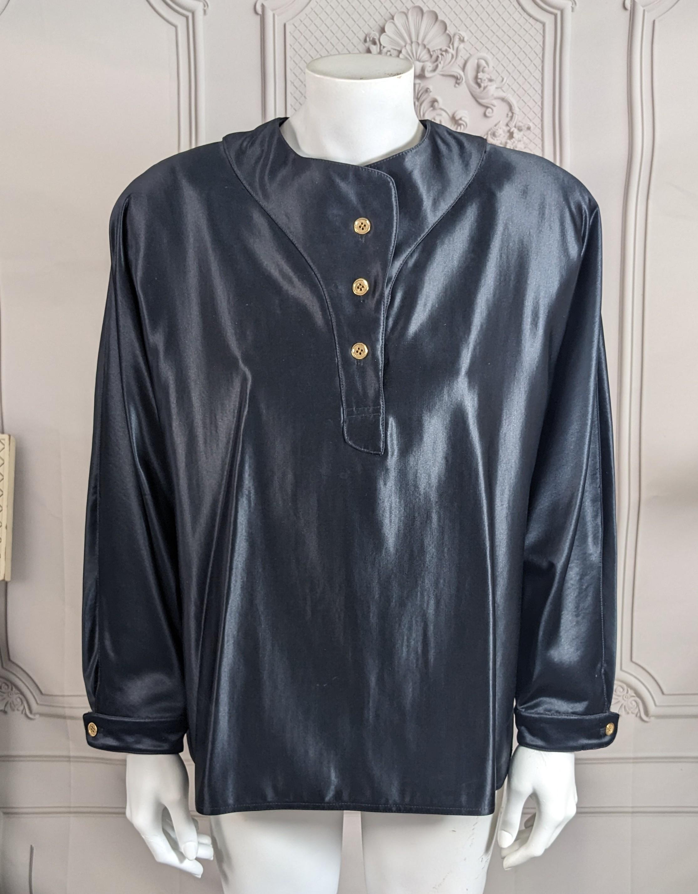 Geoffrey Beene Black Silk/Wool Satin Blouse from the 1990's. Over blouse cut with shoulder pads and men's undershirt styling which on the back features signature peter pan collar detail and large inverted pleat. Luxurious silk and wool satin textile