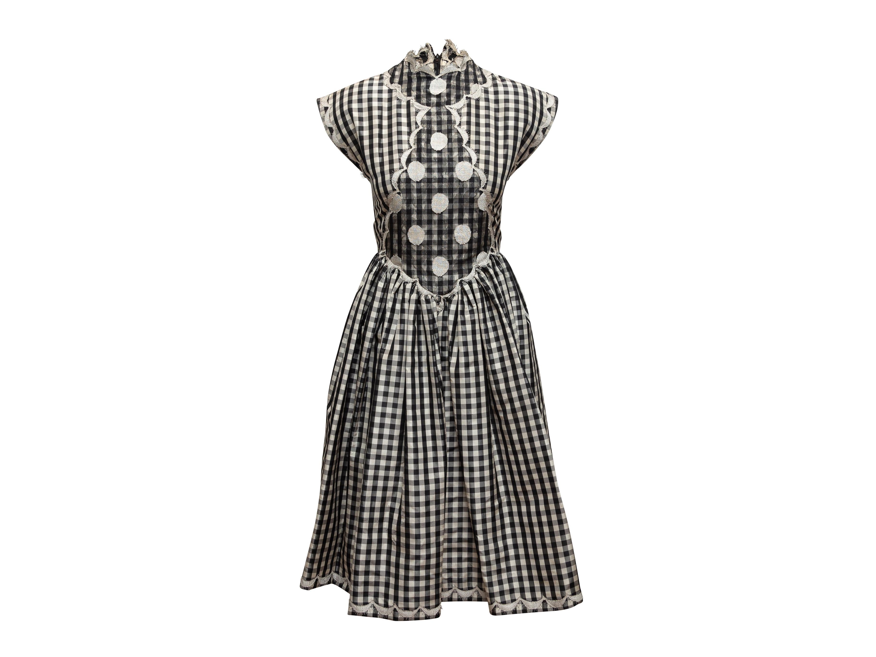Product details: Vintage black and white gingham cap sleeve dress by Geoffrey Beene. Crew neck. Polka dot lace panel detailing at front bodice. Gathering at waist. Zip closure at back. 34