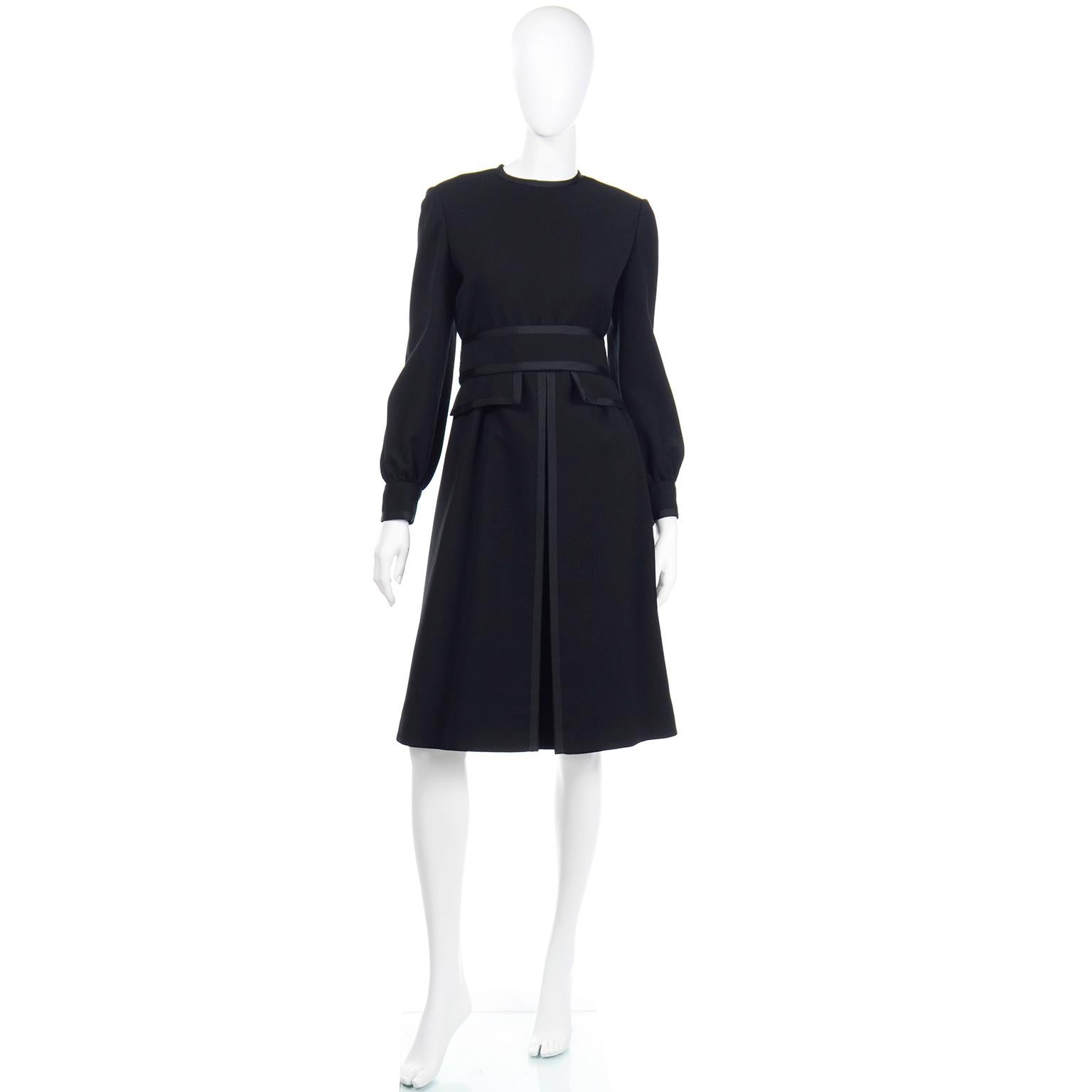 This vintage Geoffrey Beene dress is a perfect example of Mr. Beene's attention to detail and exceptional tailoring skills. The dress is in a black wool and has so many special details including the grosgrain trim that defines the pleat at the