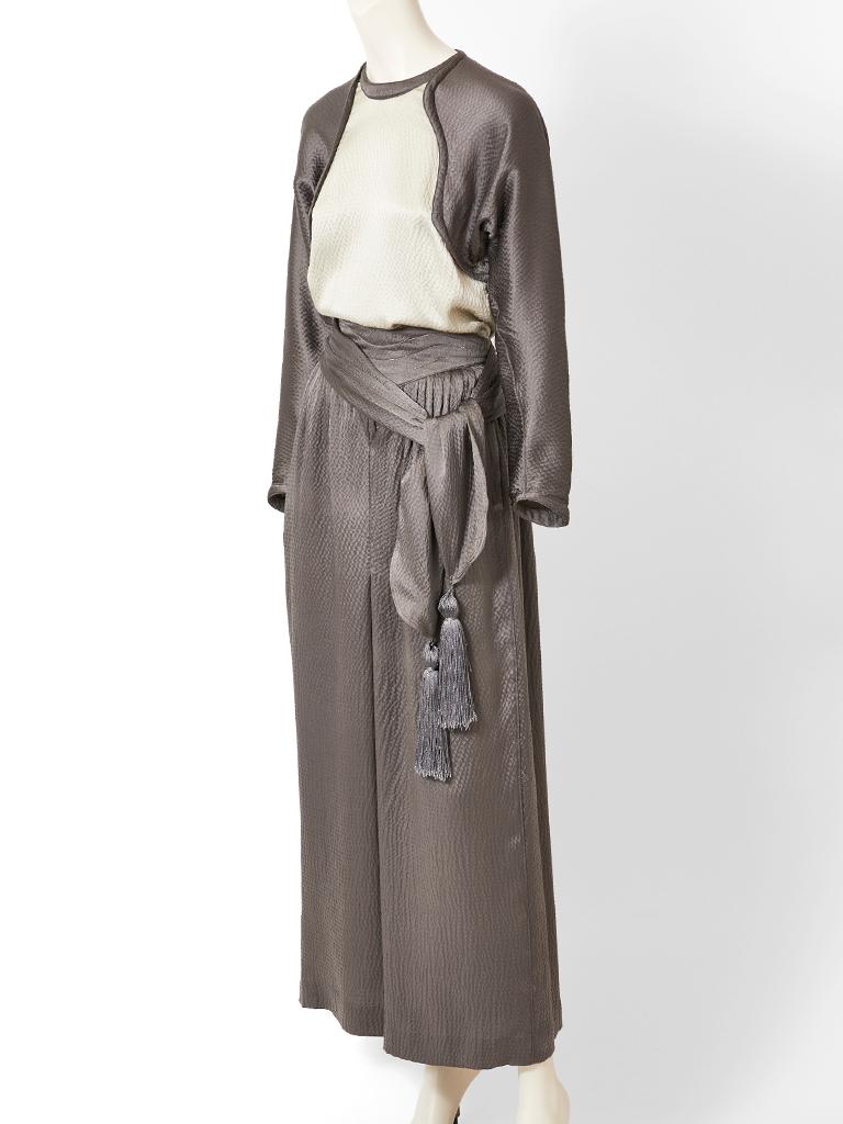 Geoffrey Beene,  pewter tone, hammered satin, top and palazzo pant ensemble. Top has a jewel neckline, with an ivory front panel and pewter tone dolman  sleeves. Pant is palazzo shape, in pewter with slight gathering at the waist. There is a wide