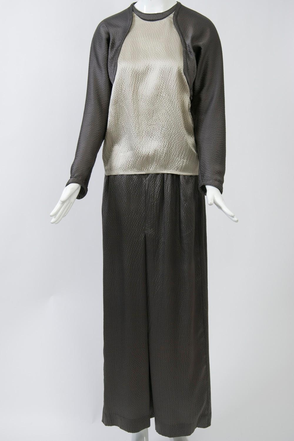 Geoffrey Beene outfit of pants, blouse and scarf crafted of a silky, puckered fabric in a sophisticated palette of taupe and beige. The outfit bears Beene's signature details of welted, curved seams in the blouse and topstitching on the curved
