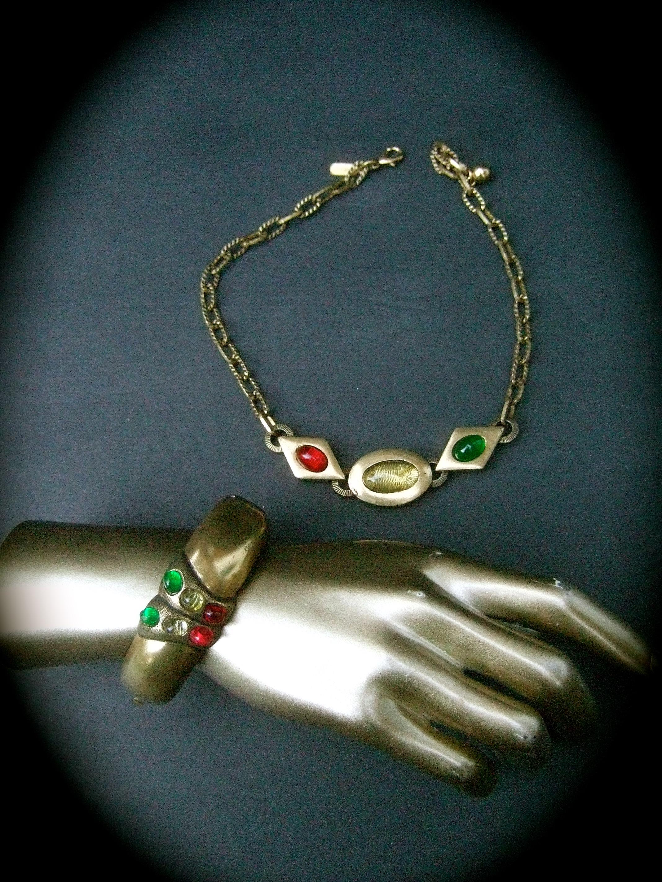 Geoffrey Beene Rare choker chain necklace & hinged bangle c 1970s 
The set is comprised of a gold matte tone metal choker necklace; embellished with three lucite cabochons in red, green & pale yellow settings

The trio of lucite cabochons are