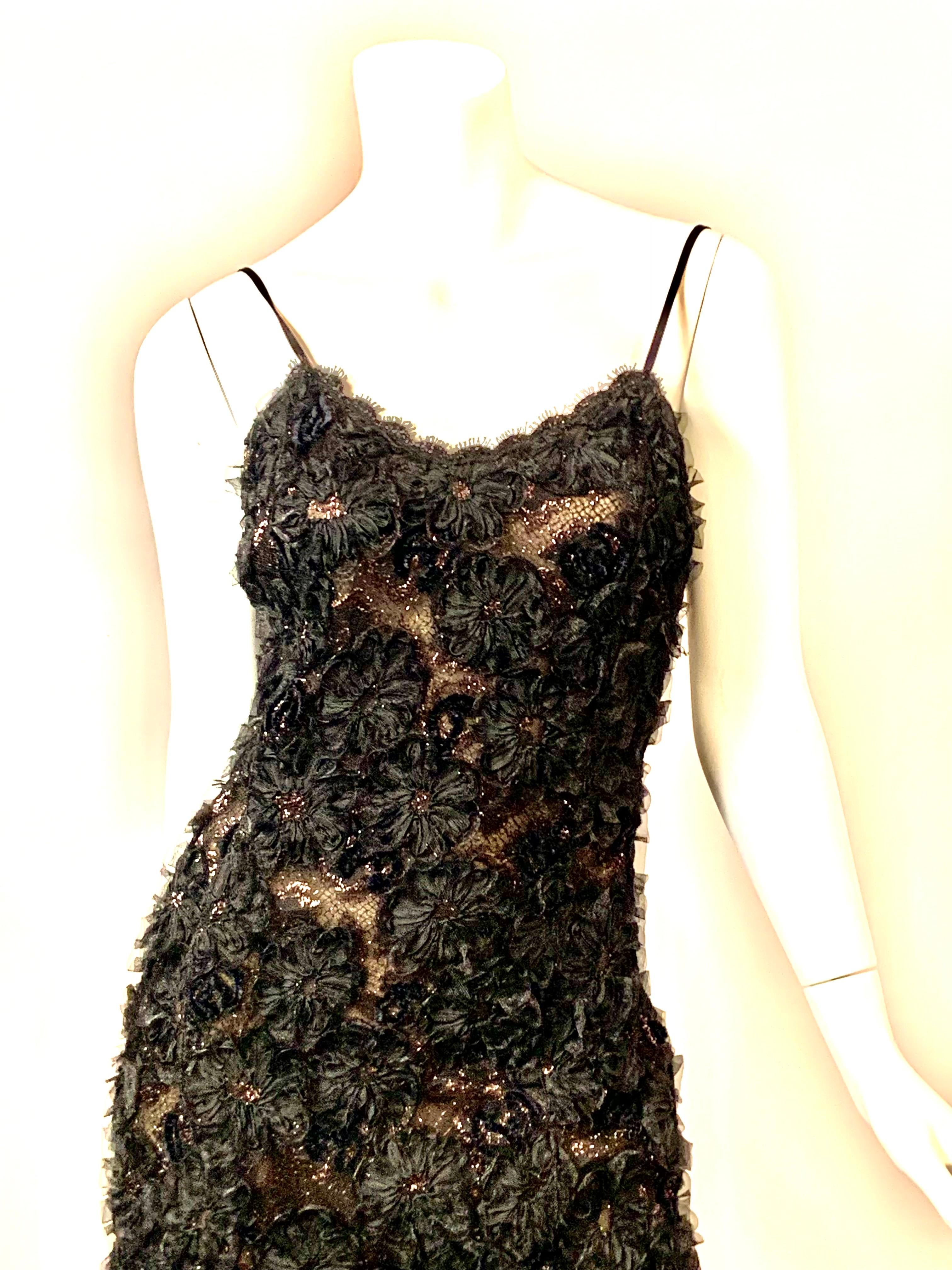 Geoffrey Beene entwarf dieses elegante, aber recht schlichte Kleid, bei dem ein sehr aufwendiger Stoff verwendet wurde, um dieses halbtransparente Abendkleid aus schwarzer Metallic-Spitze zu kreieren.
Spaghetti-Träger und ein herzförmiger Ausschnitt