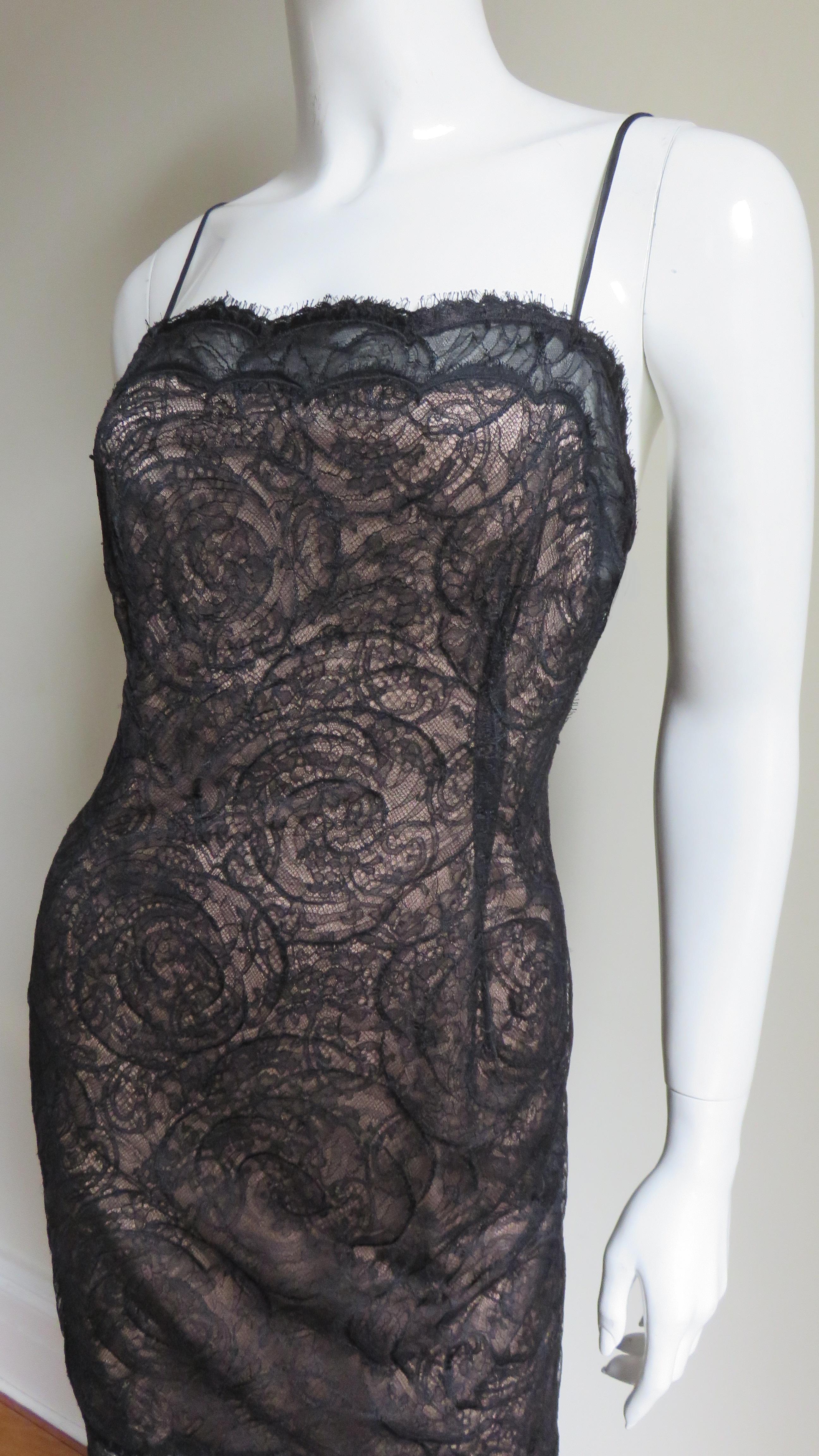 A fabulous black lace slip dress by Geoffrey Beene in an intracate, elaborate circular pattern. It has spaghetti straps with the scallop edge of the lace across the top of the dress and hem. The entire dress is lined in nude silk with the exception