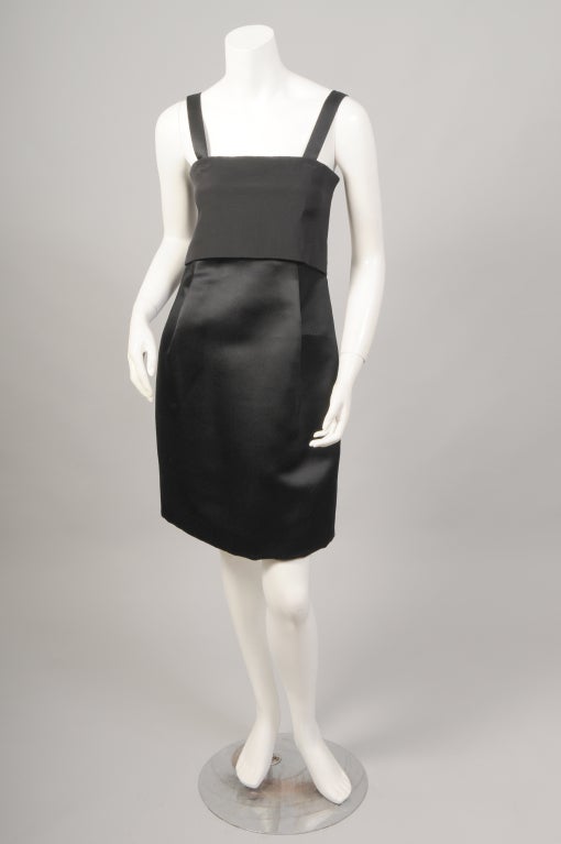 This Geoffrey Beene dress has a  combination of black silk crepe, cream satin and black satin adding  a little mystery to the dress. The bodice of silk crepe is loose in front, moving over a fitted cream satin panel. The black satin high waisted