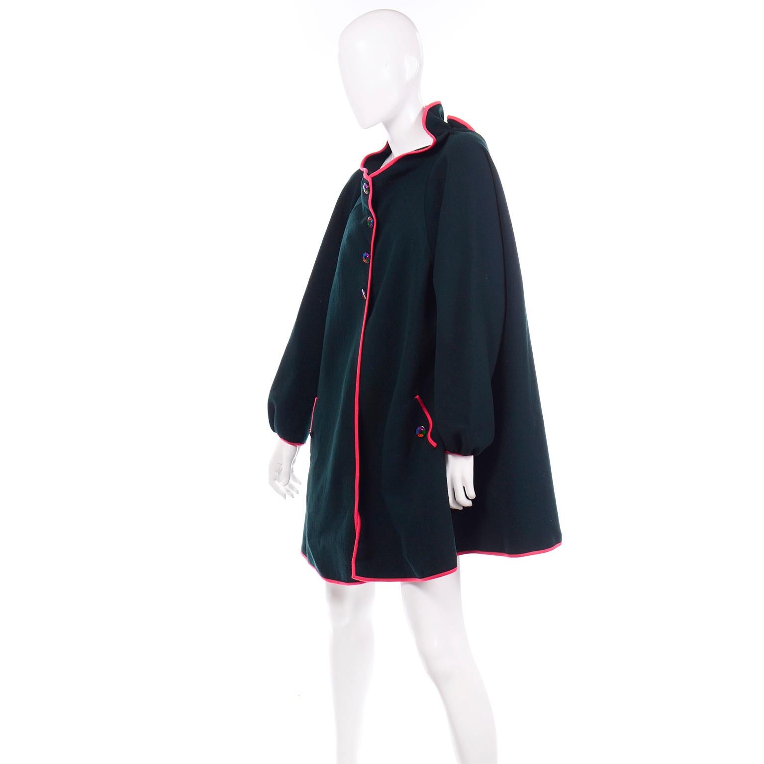 This vintage semi swing coat was designed by Geoffrey Beene and was purchased at Rizik Bos. inc in Washington DC.  This gorgeous coat is a rich deep green with raspberry red or deep pink trim and has unique multi colored buttons up the front to