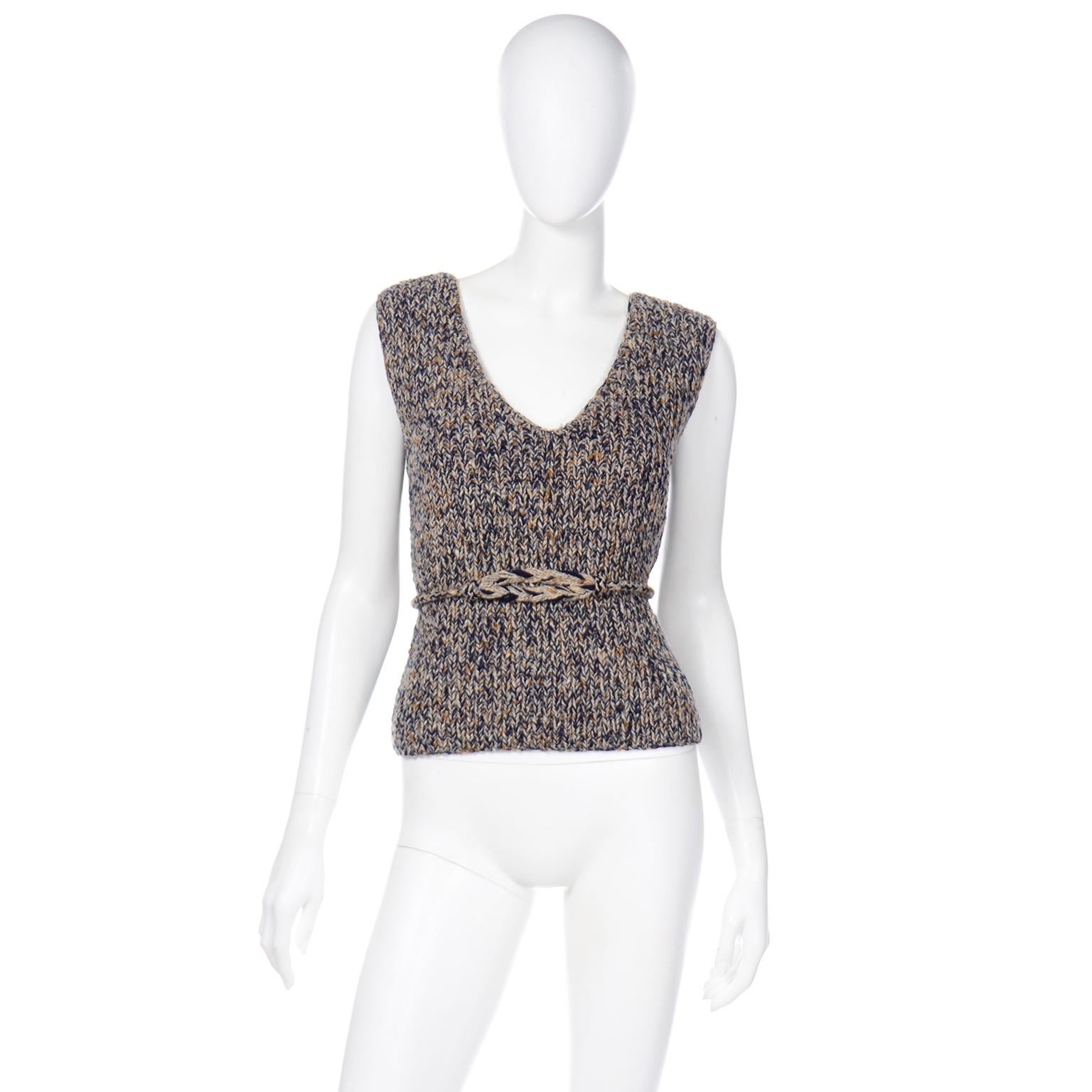 We love vintage Geoffrey Beene pieces and this wonderful blue, tan, and mustard yellow wool hand knitted sweater vest is so contemporary looking. This sweater is made of 100% Wool and has a knitted rope and braided waist belt or necktie. This is a