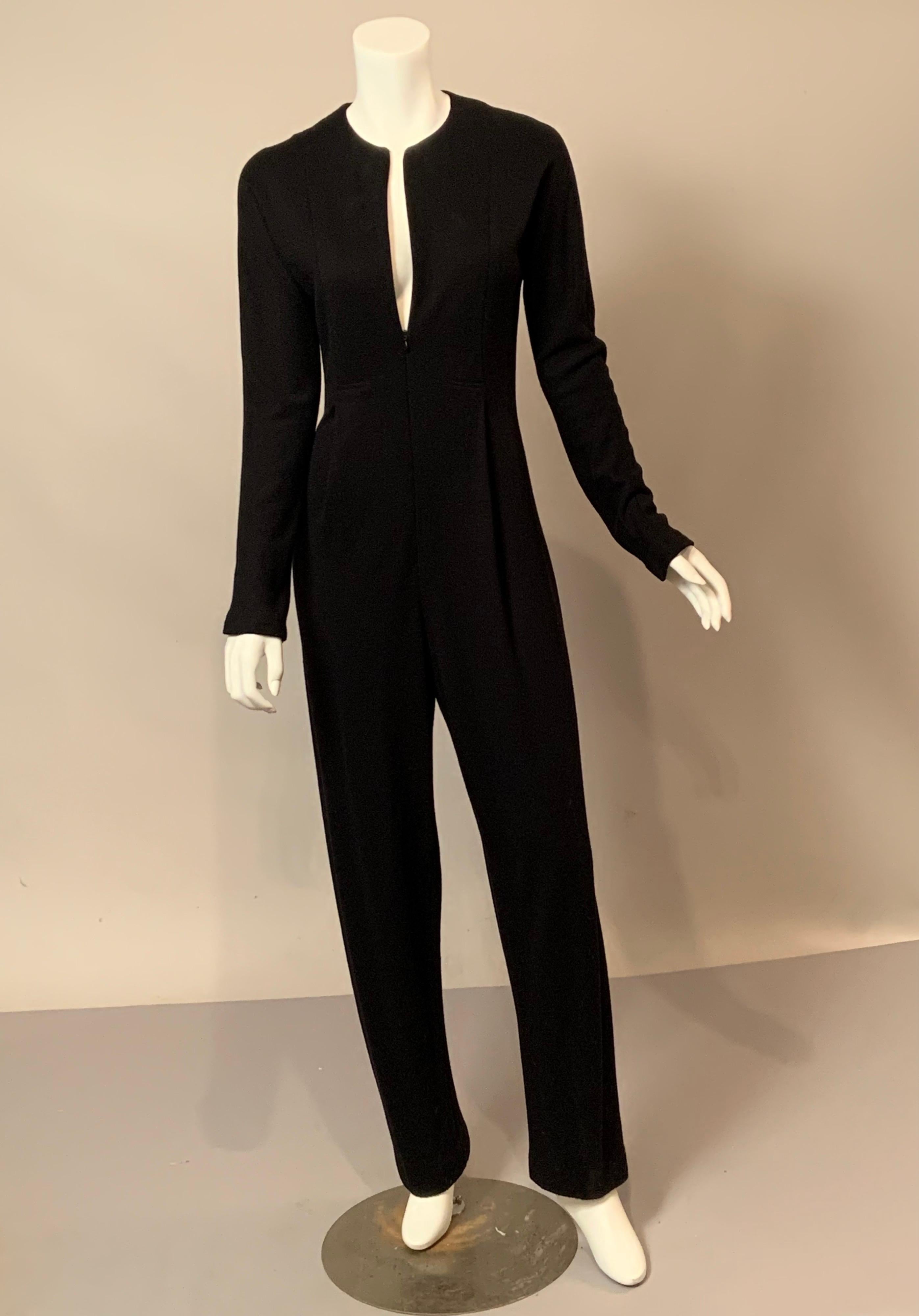 The clean spare lines of this Geoffrey Beene black wool jumpsuit are so evocative of the style of Mr. Beene.   The collarless jumpsuit has a deep center front zipper taking it from day to evening in a second.  There is a stitched down pleat on