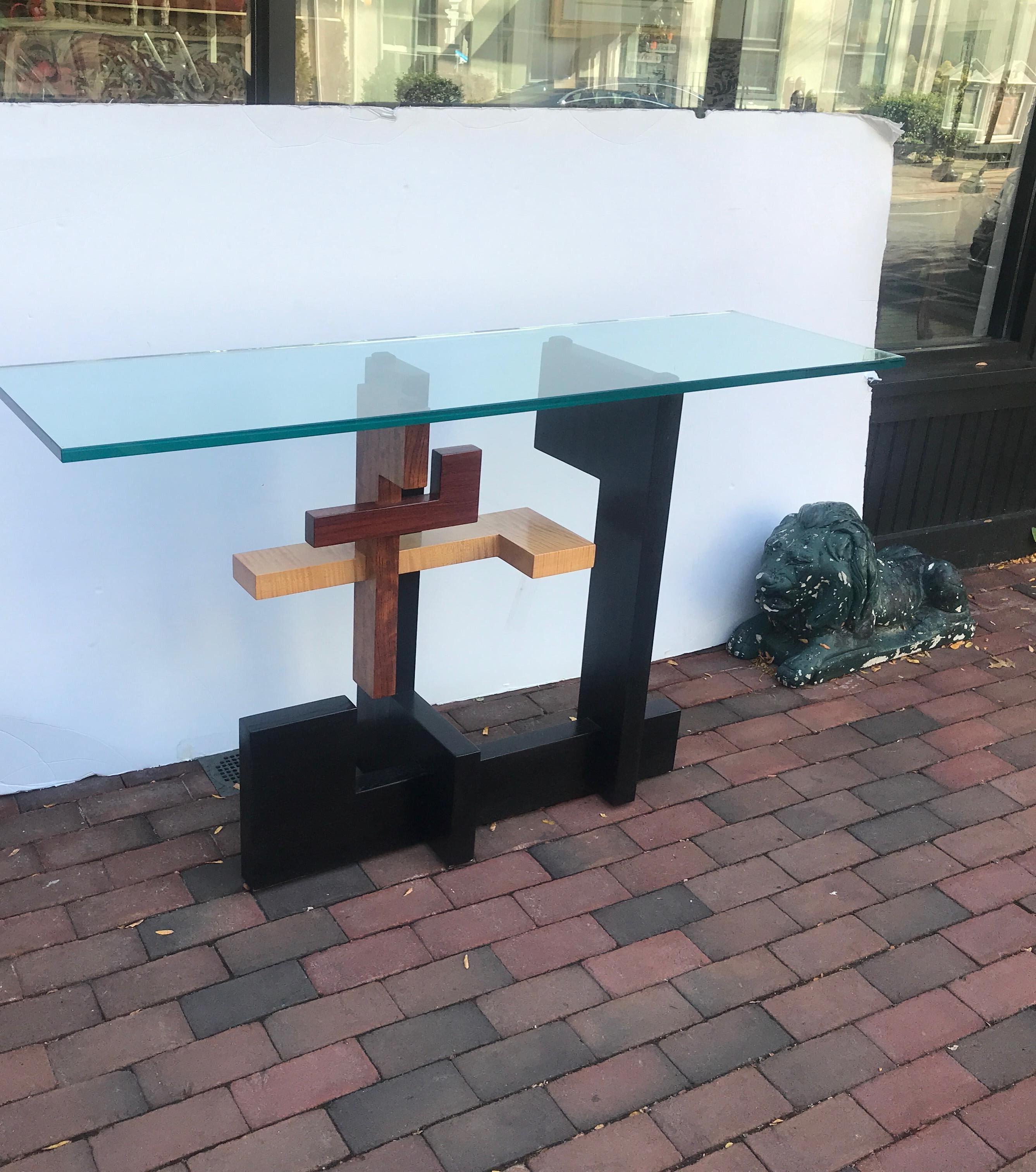 Postmodern mixed wood geometric console table with thick glass top. Signed on the underside, the tiger maple, walnut and ebonized wood in an artistically executed design.