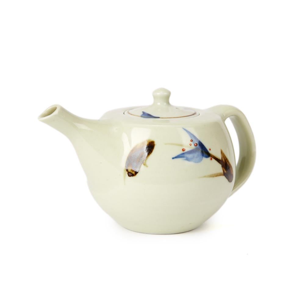 A vintage porcelain Studio Pottery teapot made at Avoncroft Pottery by Geoffrey Whiting. The teapot of squat rounded form is decorated in pale celadon glaze decorated with stylized floral stems. The teapot has a recessed cover and has an impressed