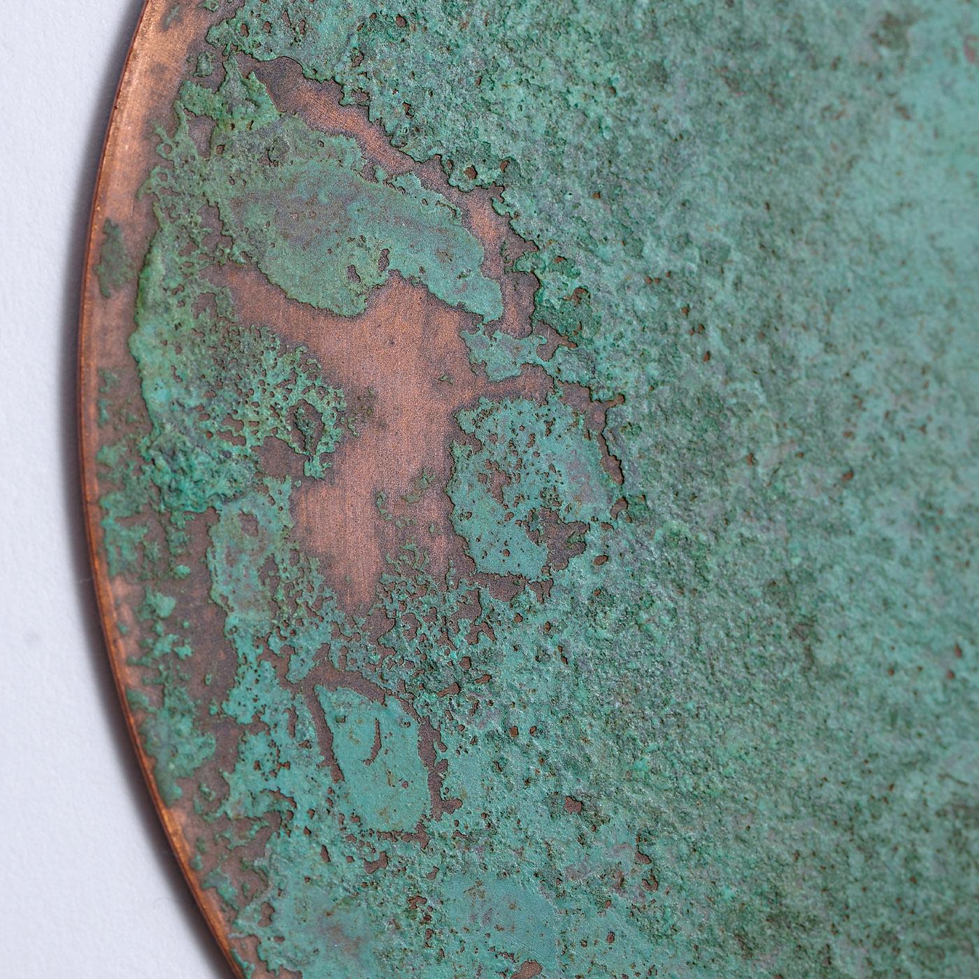 A captivating verdigris patina emerging from an oxidized copper backdrop defines the raw charm of this set comprised of six coasters. Each piece results from a meticulous artisan process and implies singular traceries and hues sealing them as