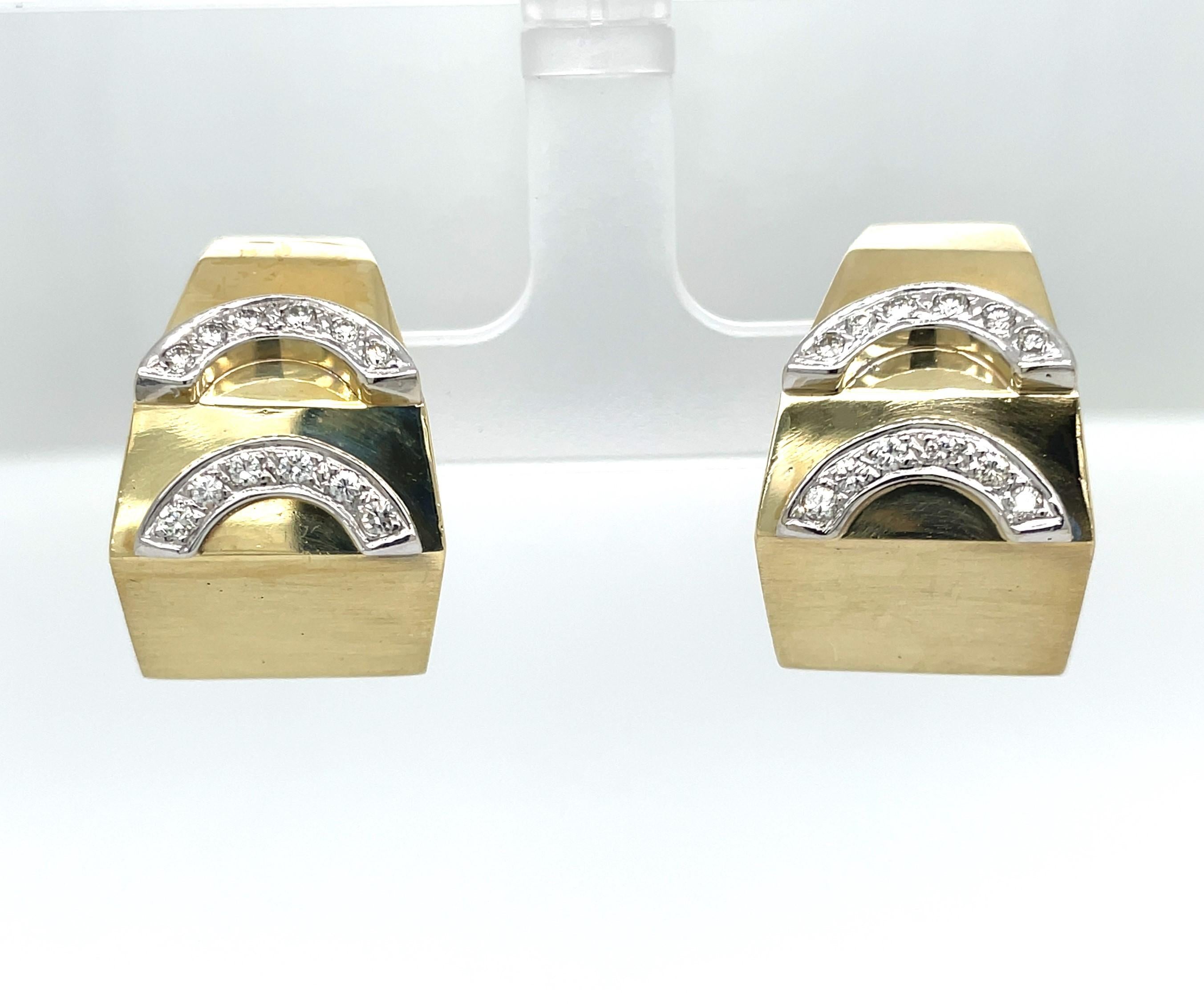 Uniquely geometric as a flat-side wide angled hoop earring pair this bold design also has a  pyramid-like shape gradating from 3/8 in to 1/2 inch to 5/8 all created in satin 14 karat yellow gold. Diamond appliques are channel-set in gold forming a