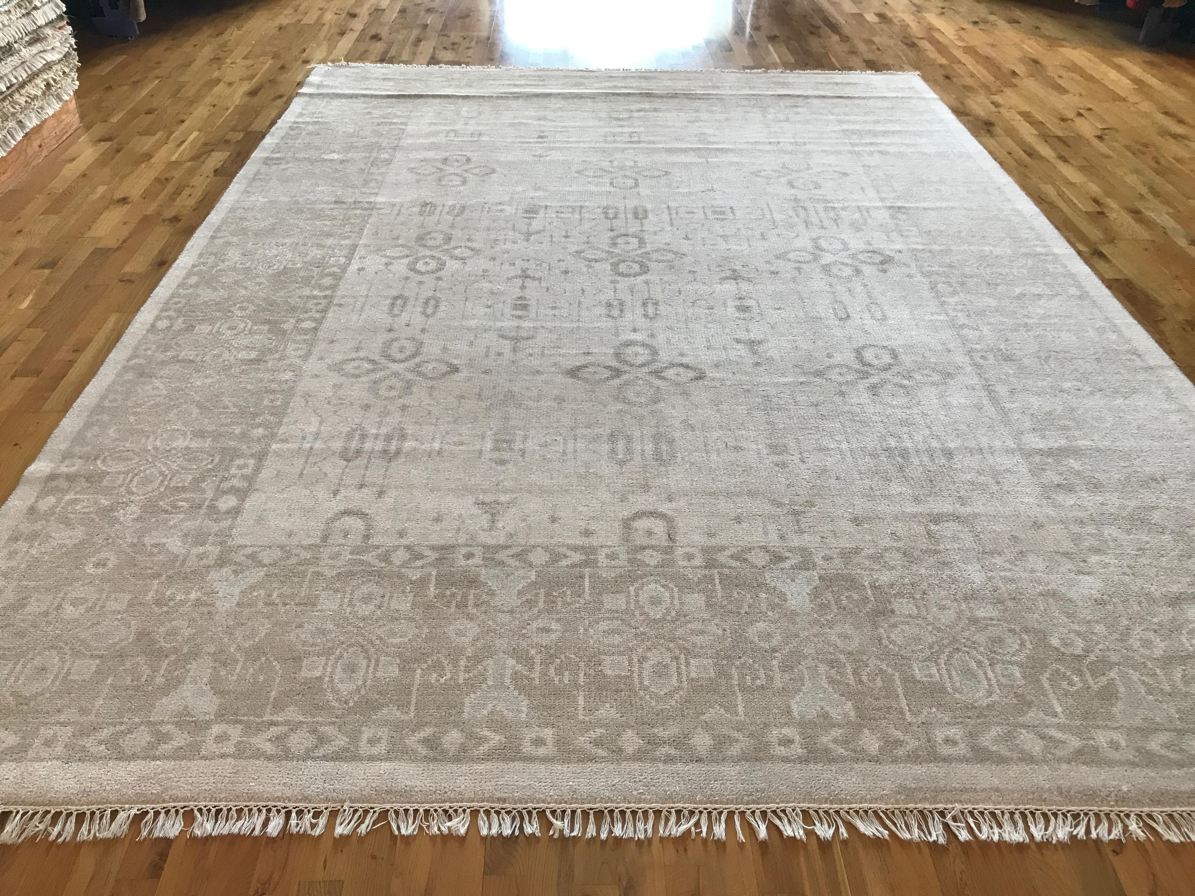 Traditional style rug with geometric and floral pattern that would be equally at home in a contemporary setting. Colors are light beige, ivory, dark beige, brown and hues of gray.

- All wool

- Hand knotted in India.
