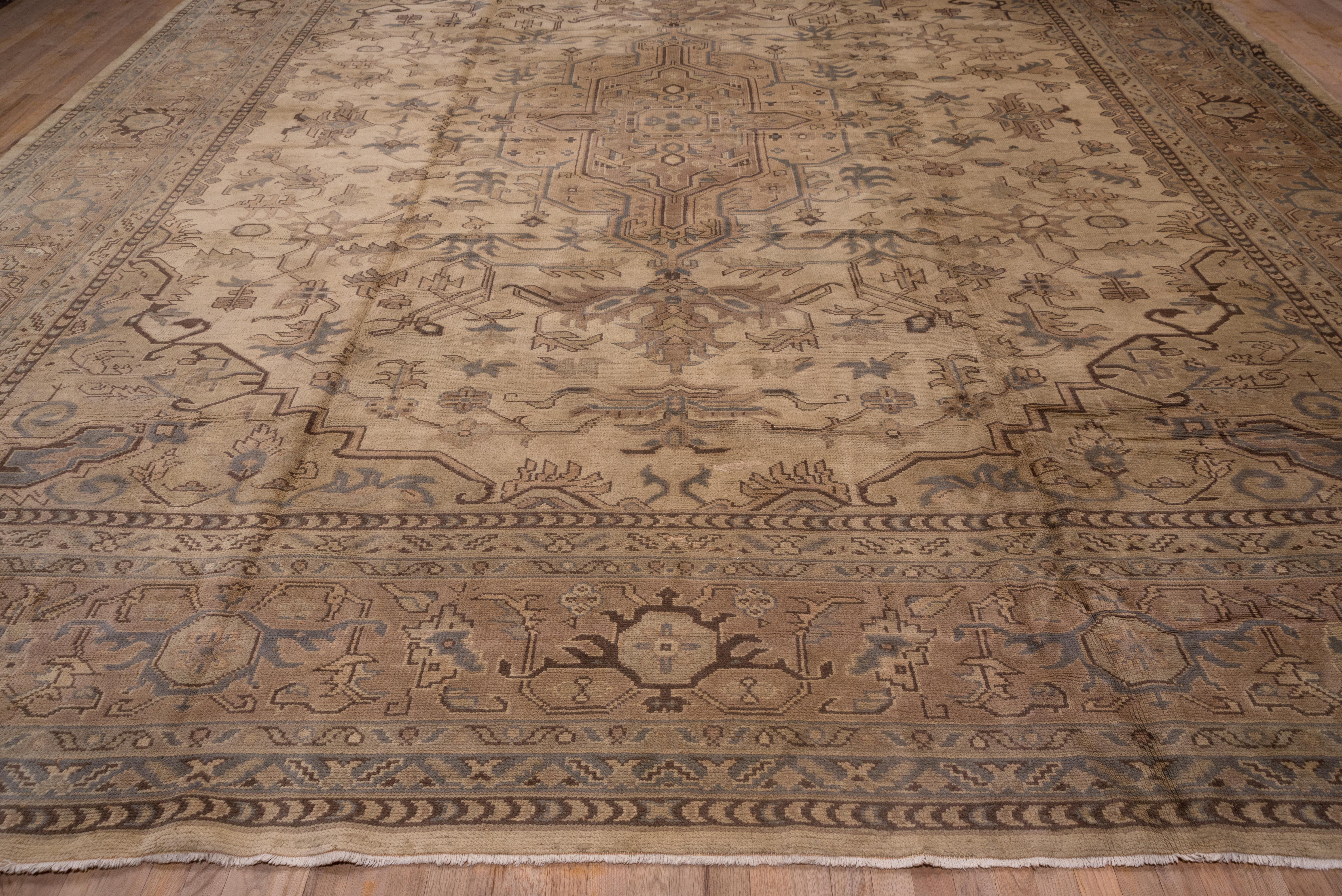 This western Turkish town room size was copied closely from a Persian Heriz with a layered geometric medallion, semi-en suite corners and severely angular leaves, flowers and vines. The pale green turtle palmette border is also totally in the Heriz