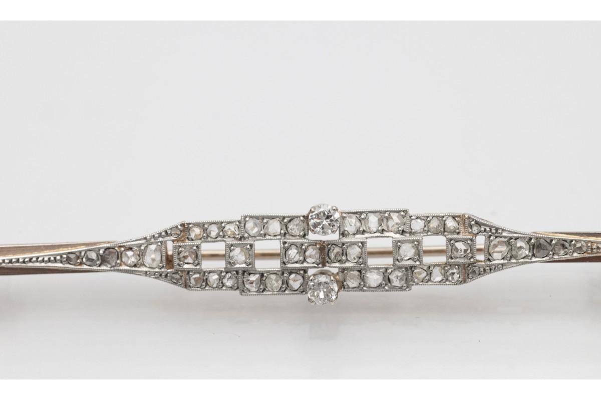 Art Deco brooch made of 18-karat yellow gold and platinum with 0.79ct diamonds.

Geometric elongated shape of the brooch decorated with 2 diamonds in an 