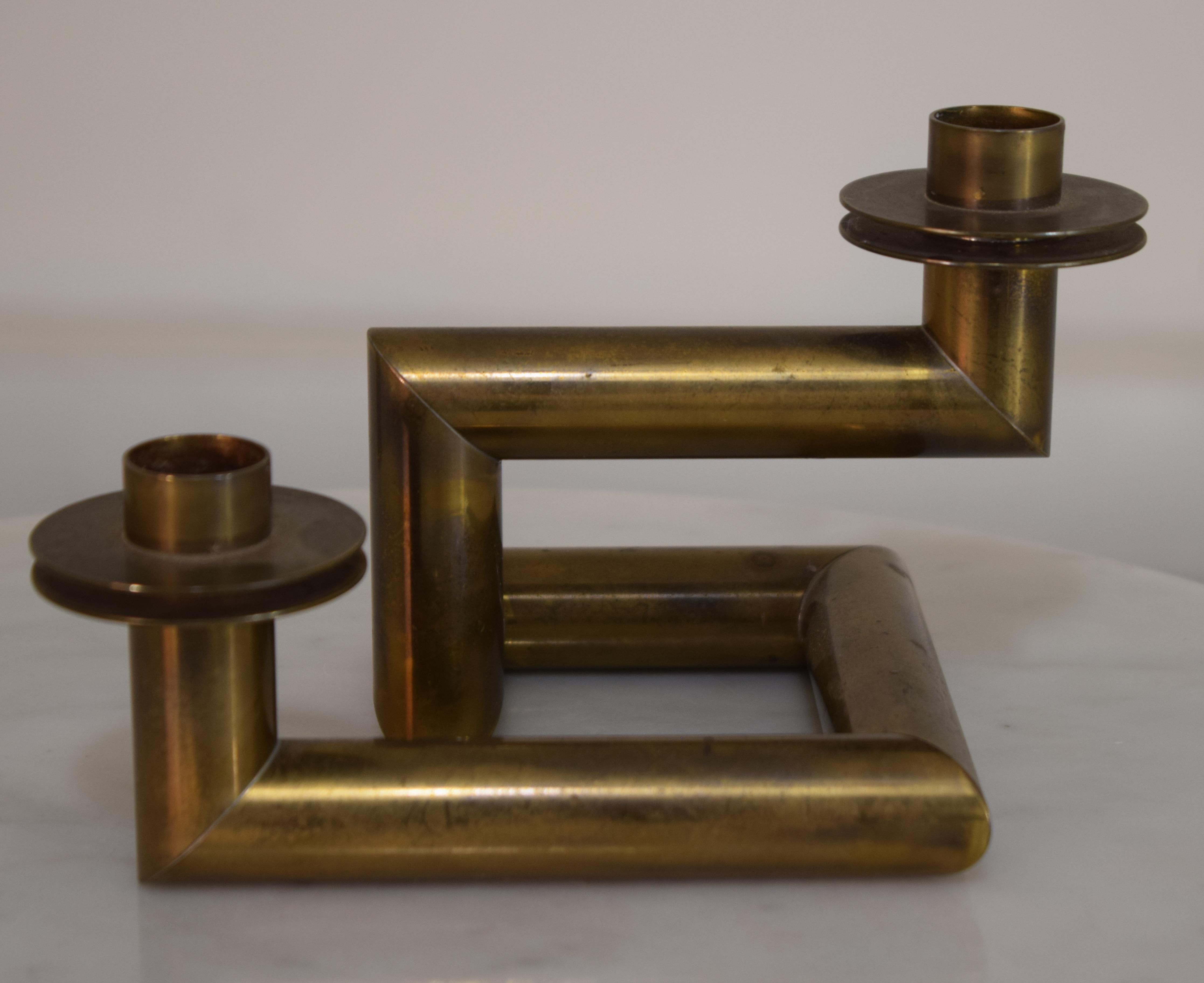 Production date unknown. Assumed 1950's. comprises of welded brass tube with 2 removable candle spouts for insertion of candles. No markings. Work would compliment a machine age or Frank Lloyd Wright style table setting. Measures 6.5