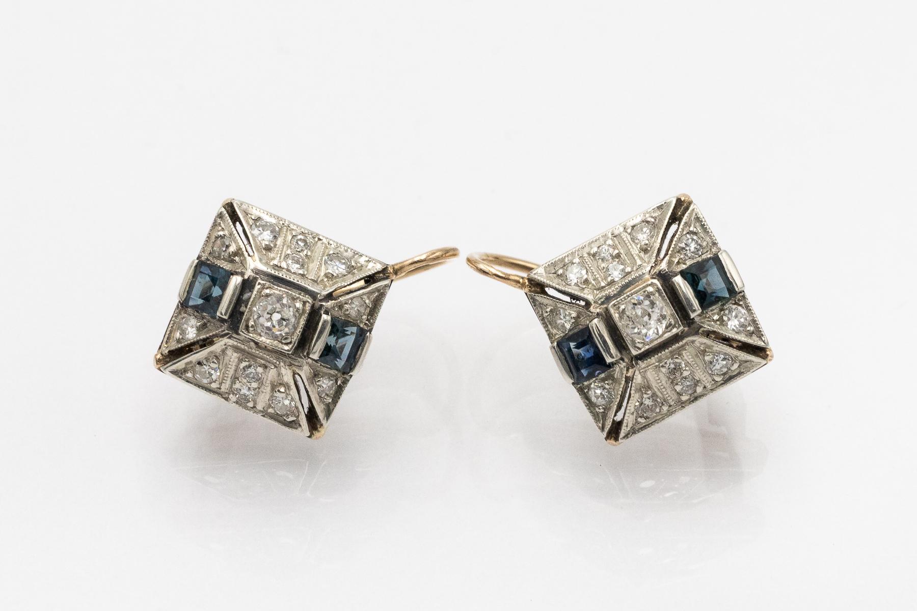 Geometrische Vintage Art Deco Ohrringe mit Diamanten und Saphiren

Ohrringe aus 14 Karat Gelbgold und Silberelementen in Steinfassungen.

Herkunft: Österreich-Ungarn, Pest, 1920er Jahre - Punze erhalten.

Die Ohrringe sind mit Saphiren im