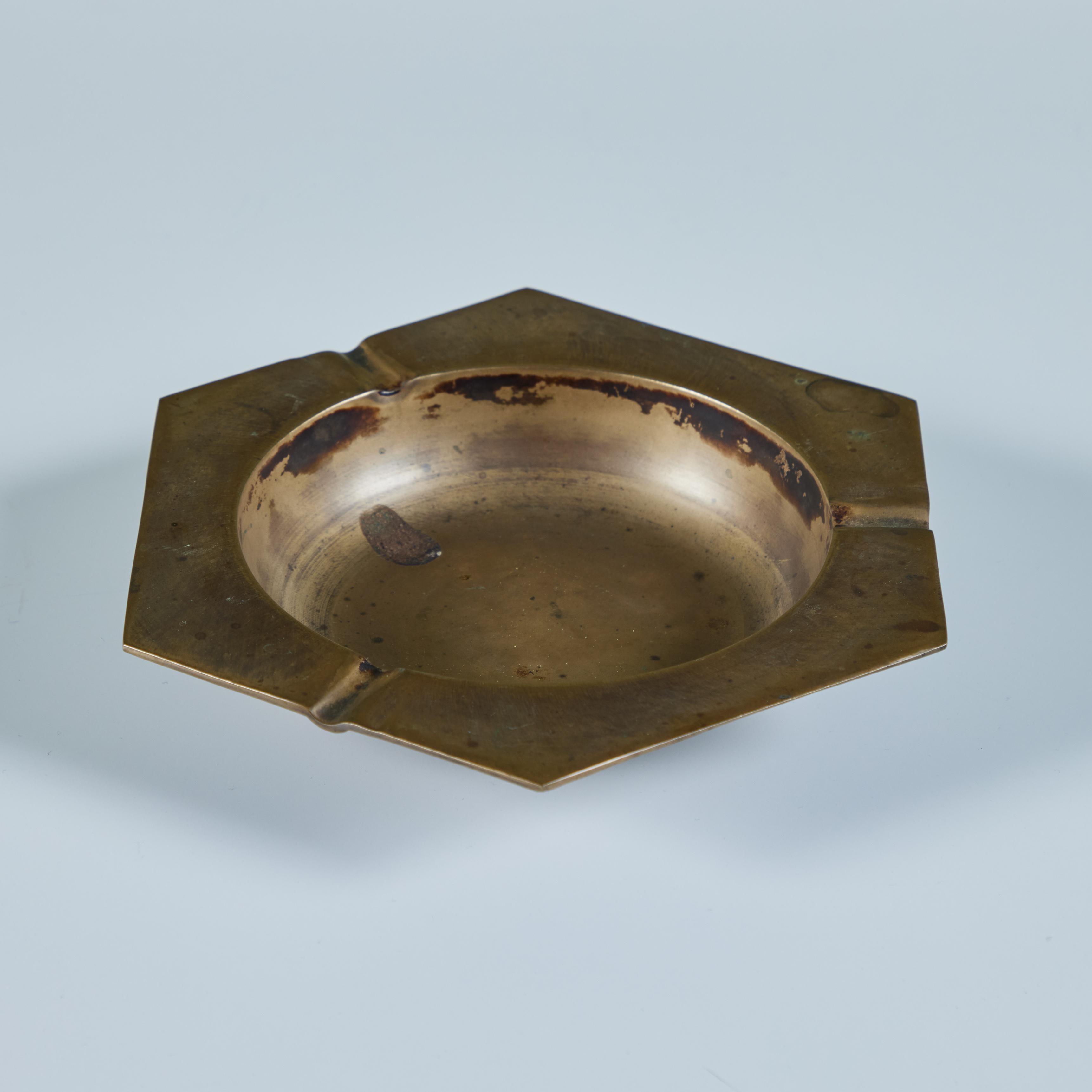 Brass hexagonal ashtray featuring a deep round well with three divots on alternating sides.

Dimensions
7.25