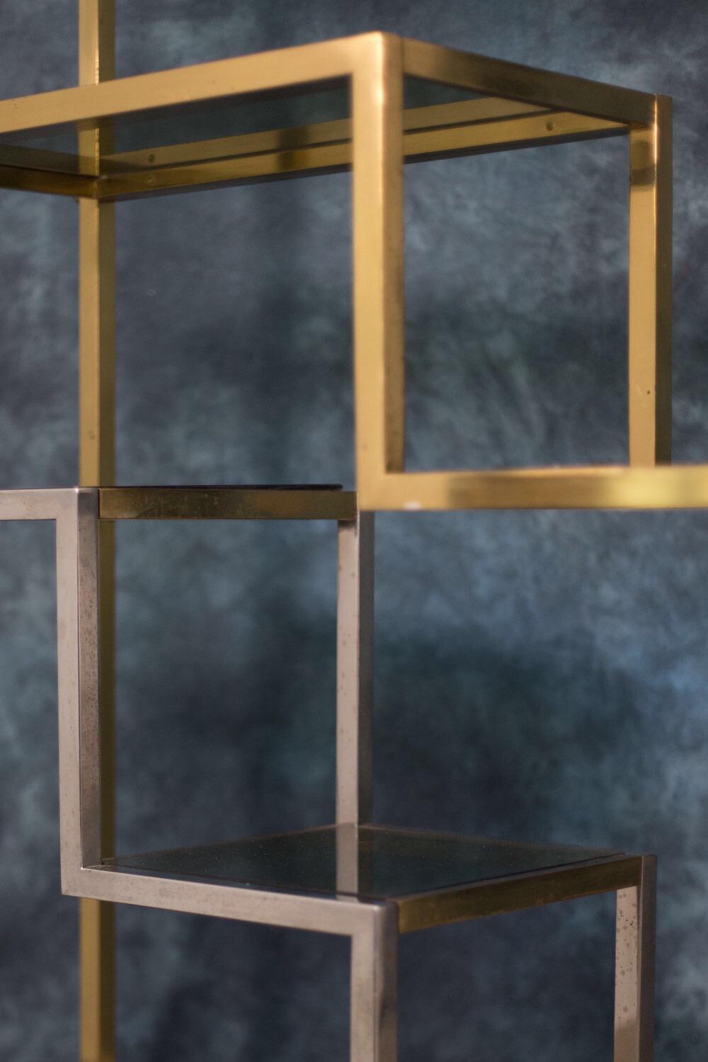 Romeo Rega designed and made this brass étagère in the early 1970s.
It features the beautiful detail of a structure made of gold, and chromed brass shelves.
The shelf shape was designed for optimal capacity.
The structure rests on a black