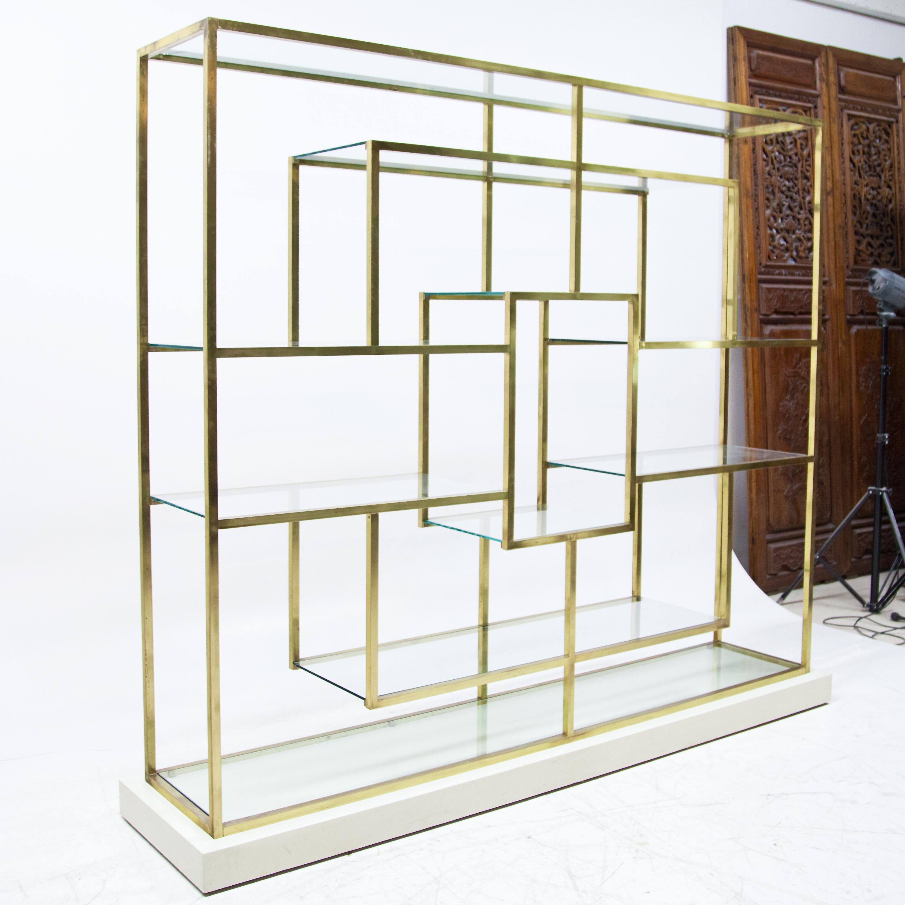 Large shelving unit with geometric brass frame and glass shelves in the style of Romeo Rega.