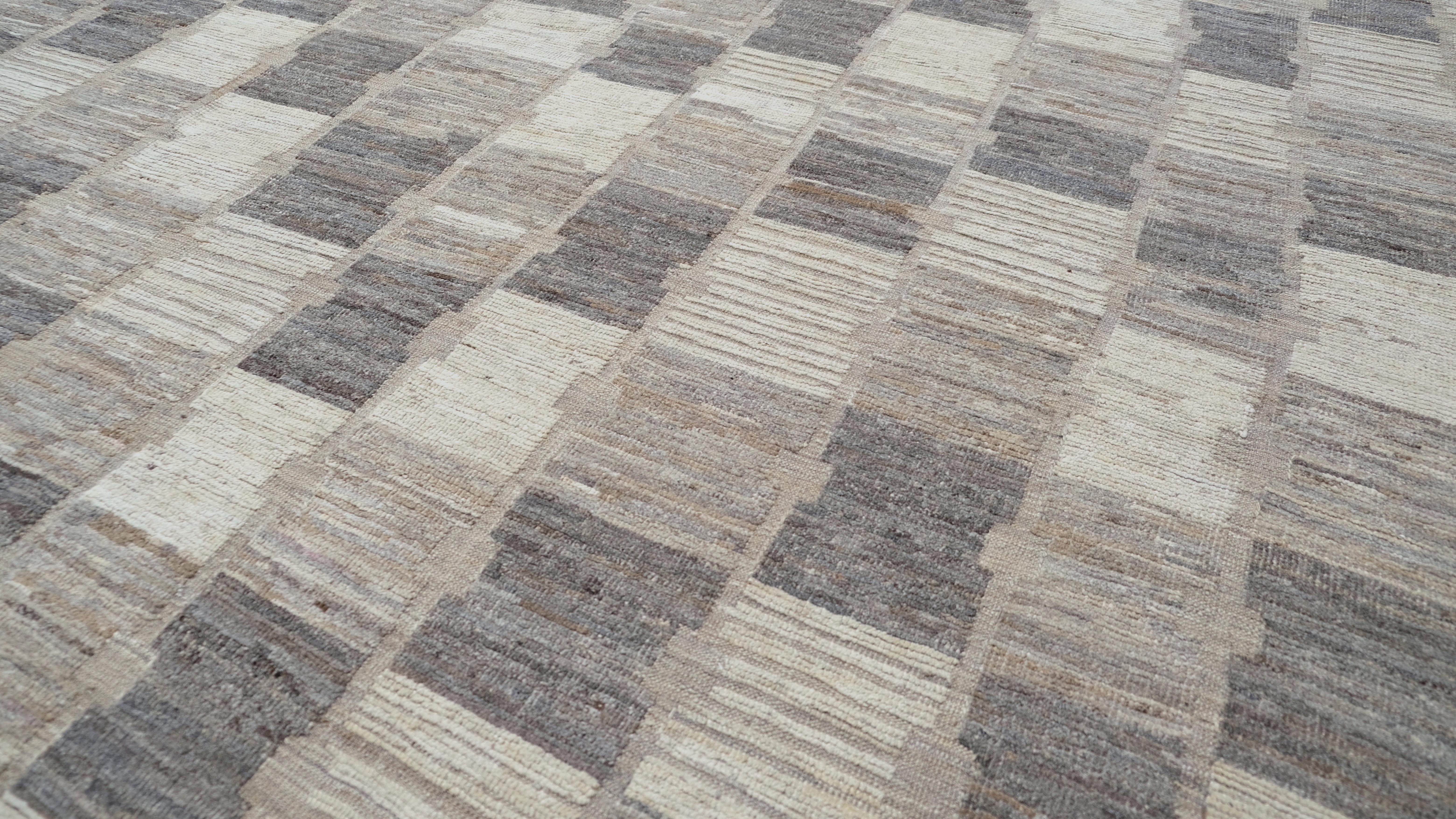 Dieser exquisite, handgeknüpfte Wollteppich weist ein faszinierendes geometrisches Schachbrettmuster auf, das einen atemberaubenden  Effekt, der jedes Interieur mit Tiefe und moderner Eleganz aufwertet. Dieser Teppich ist in neutralen Grau-,