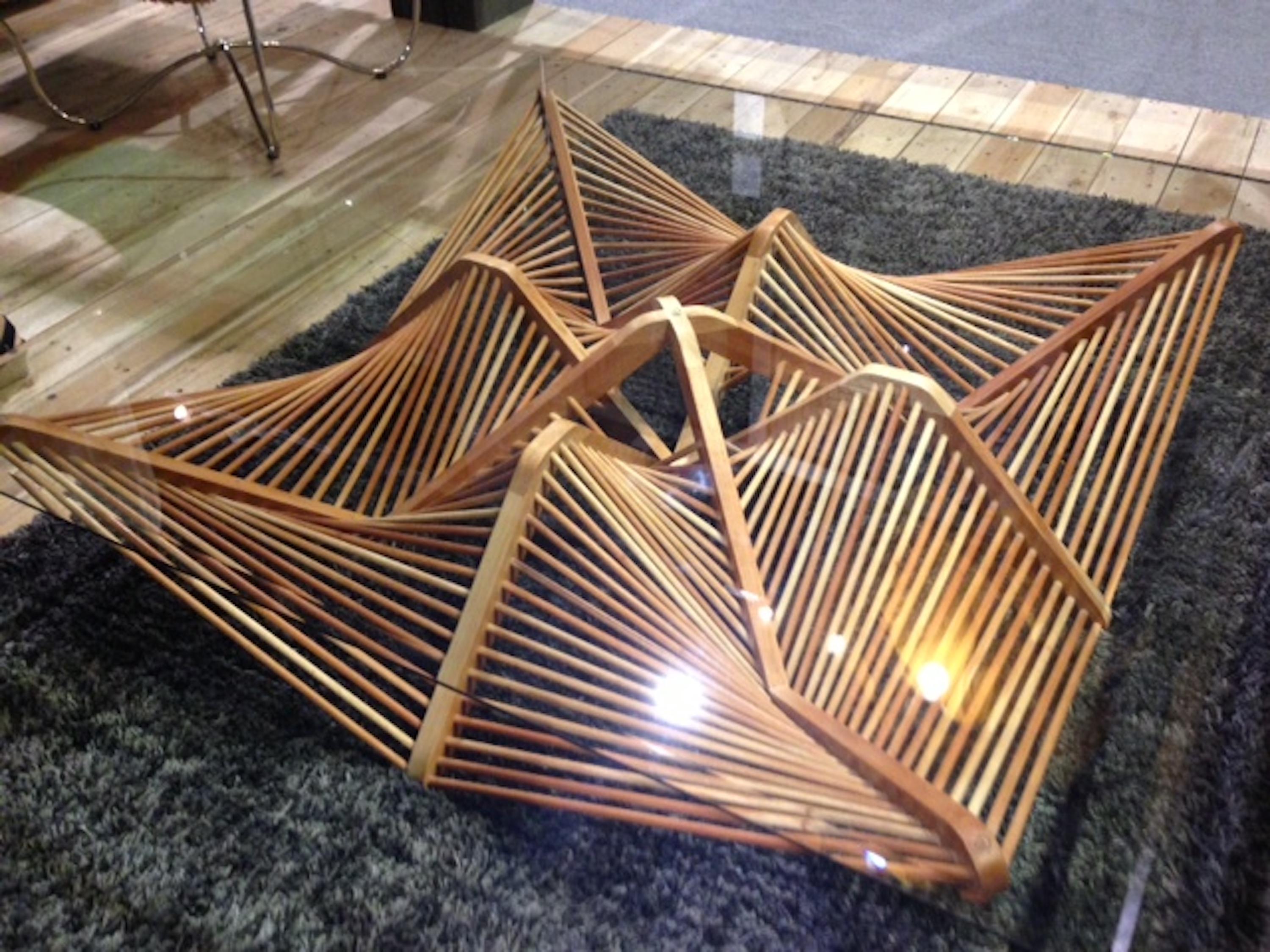 This innovative design, conceived by Vito Selma, showcases a captivating arrangement of geometric shapes crafted with lauan wood. The bold web of interconnected shapes adds an element of intrigue to the overall design. With its unique construction,