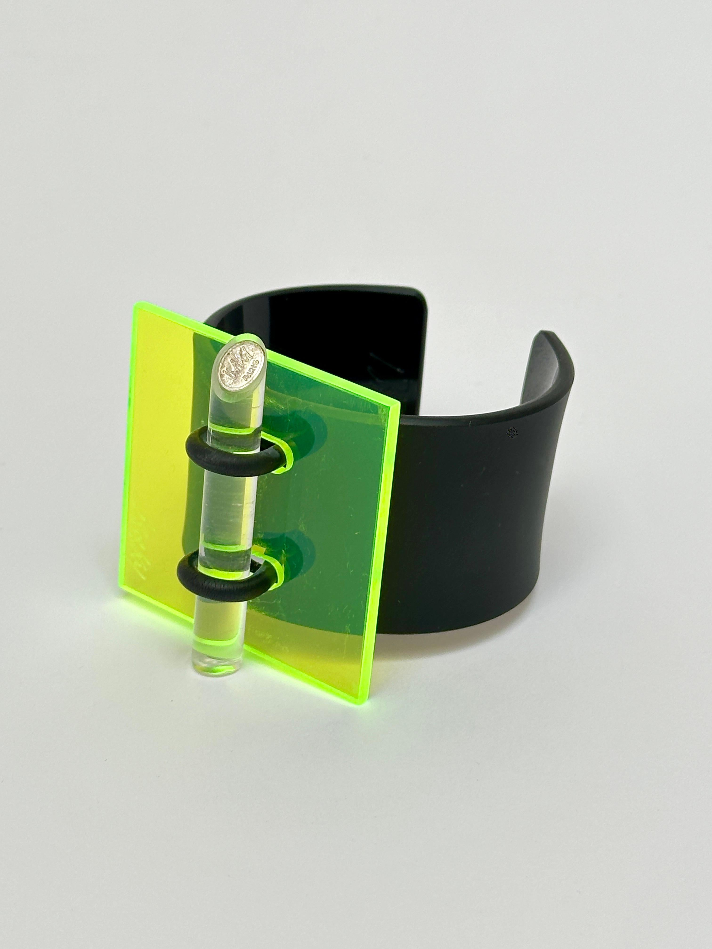 Methacrylate plate fixed by a rubber link on a black acrylic bracelet, matt exterior and glossy interior, locked by an altugas rod wearing the Artist's brand.

Both the facade and the bracelet are hand signed.

Measurements (cm) 
square 5.3 x