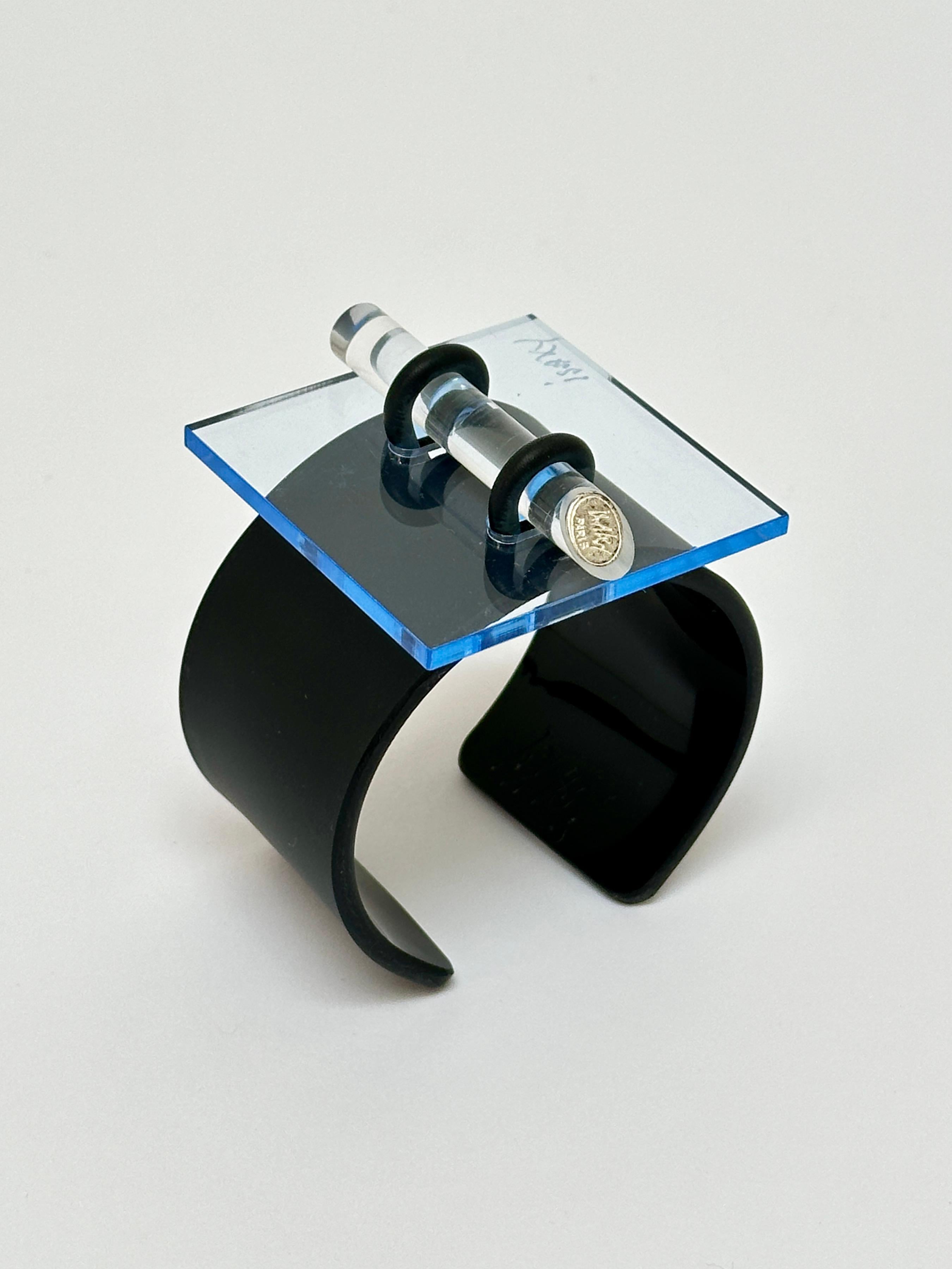Methacrylate plate fixed by a rubber link on a black acrylic bracelet, matt exterior and glossy interior, locked by an altugas rod wearing the Artist's brand.

Both the facade and the bracelet are hand signed.

Measurements (cm) 
square 5.3 x