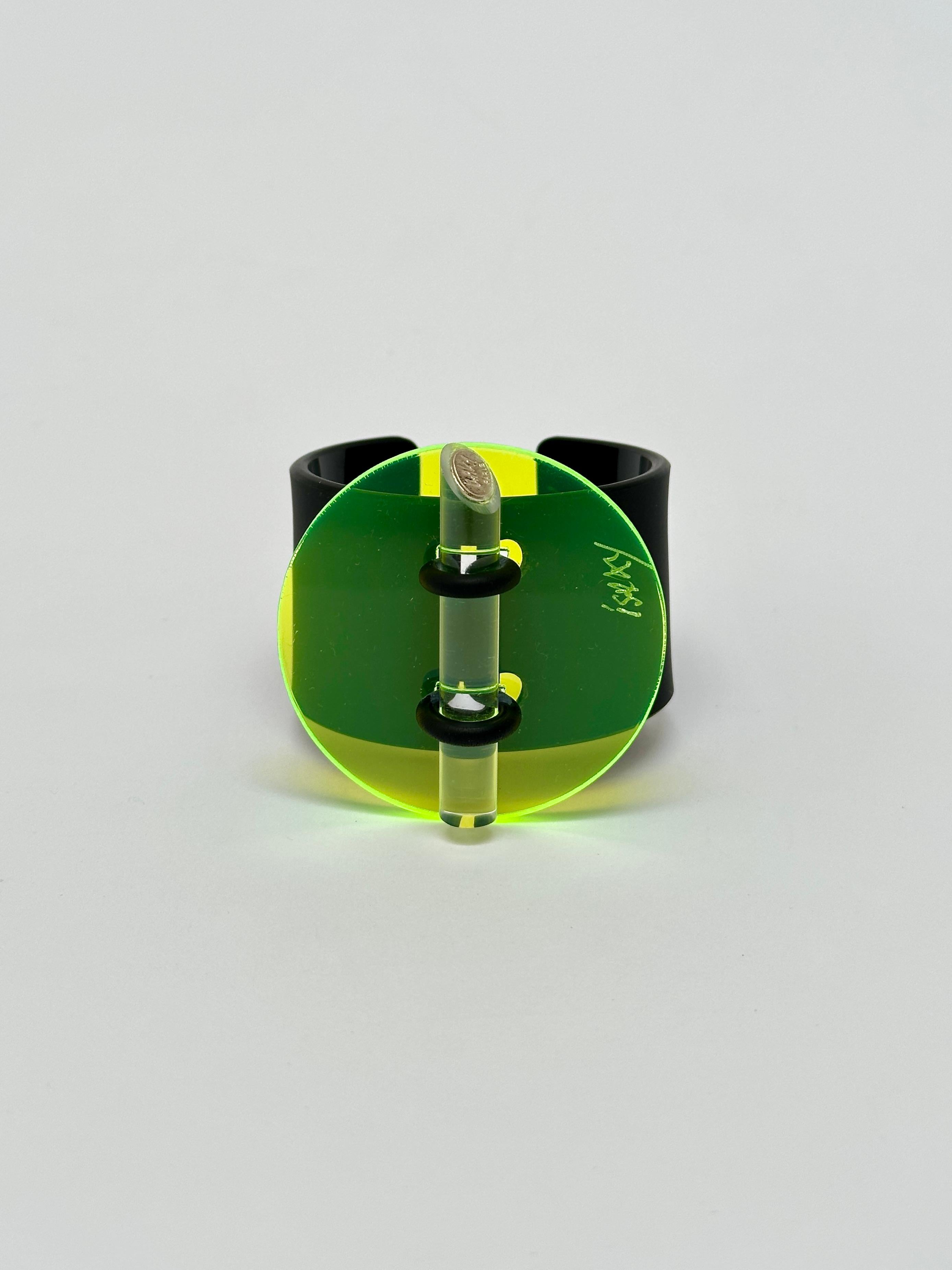 Methacrylate plate fixed by a rubber link on a black acrylic bracelet, matt exterior and glossy interior, locked by an altugas rod wearing the Artist's brand.

Both the facade and the bracelet are hand signed.

Measurements (cm) 
circle 6.3