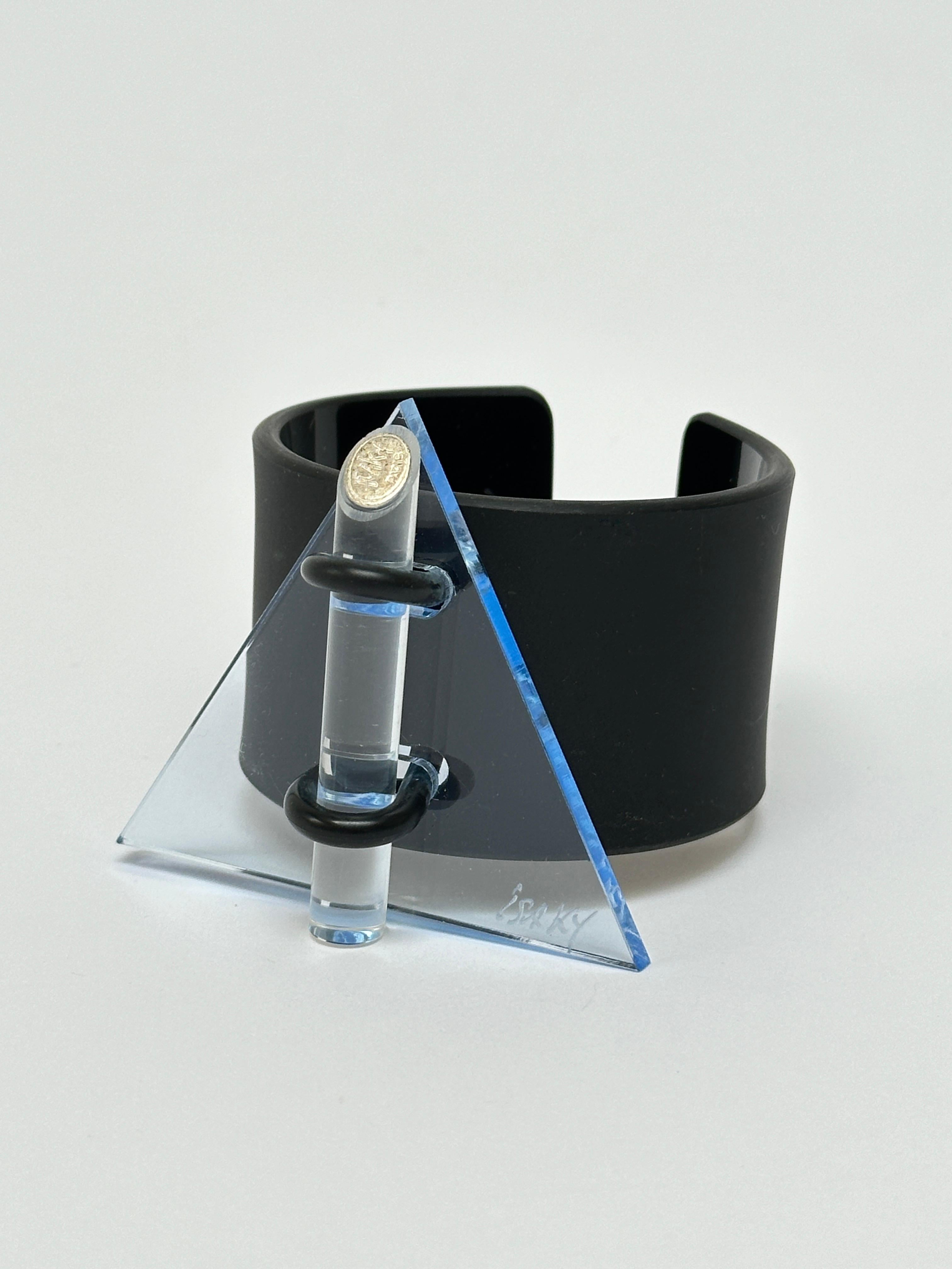 Methacrylate plate fixed by a rubber link on a black acrylic bracelet, matt exterior and glossy interior, locked by an altugas rod wearing the Artist's brand.

Both the facade and the bracelet are hand signed.

Measurements (cm) 
triangle's side