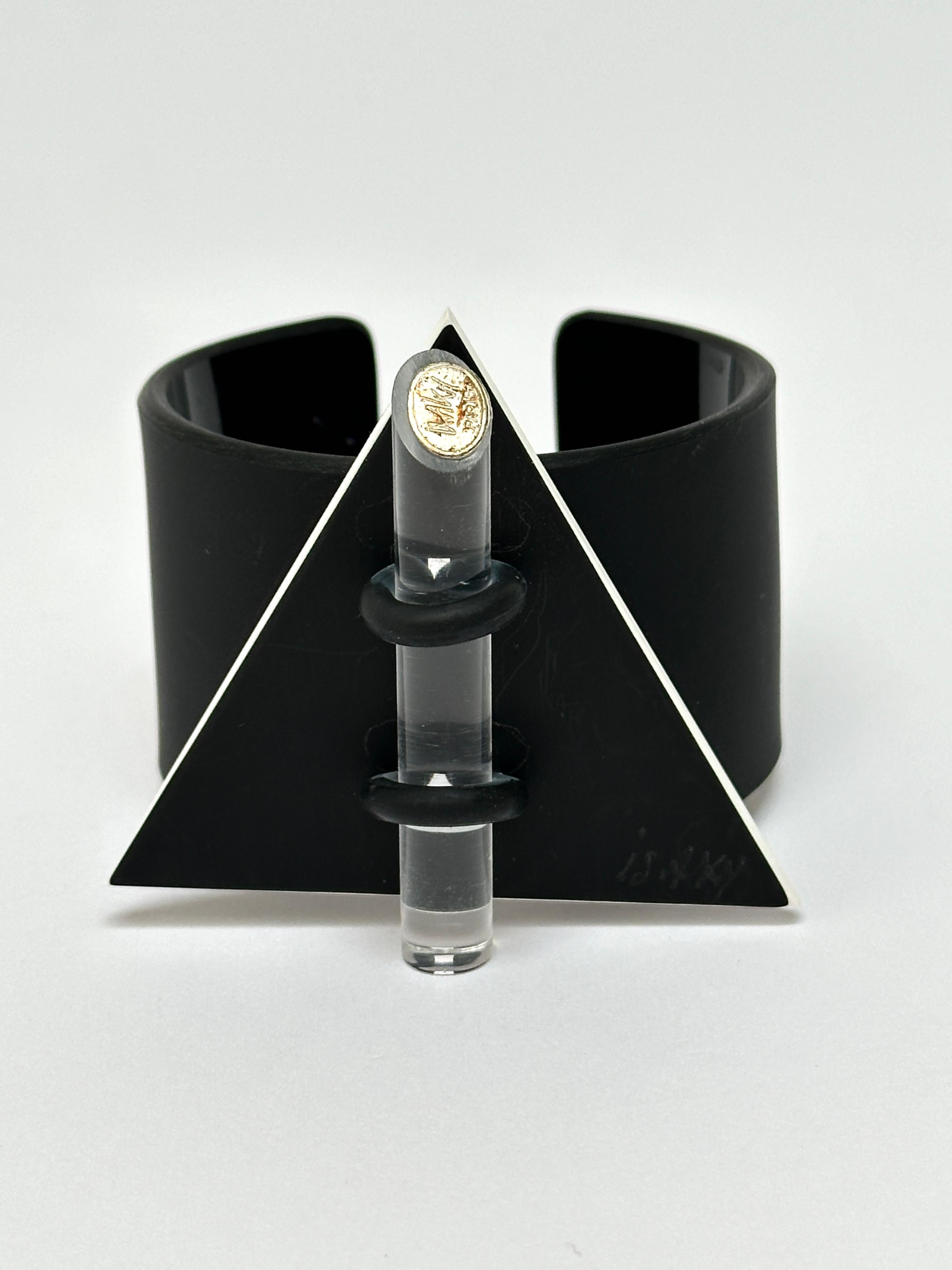 Methacrylate plate fixed by a rubber link on a black acrylic bracelet, matt exterior and glossy interior, locked by an altugas rod wearing the Artist's brand.

Both the facade and the bracelet are hand signed.

Measurements (cm) 
triangle's side
