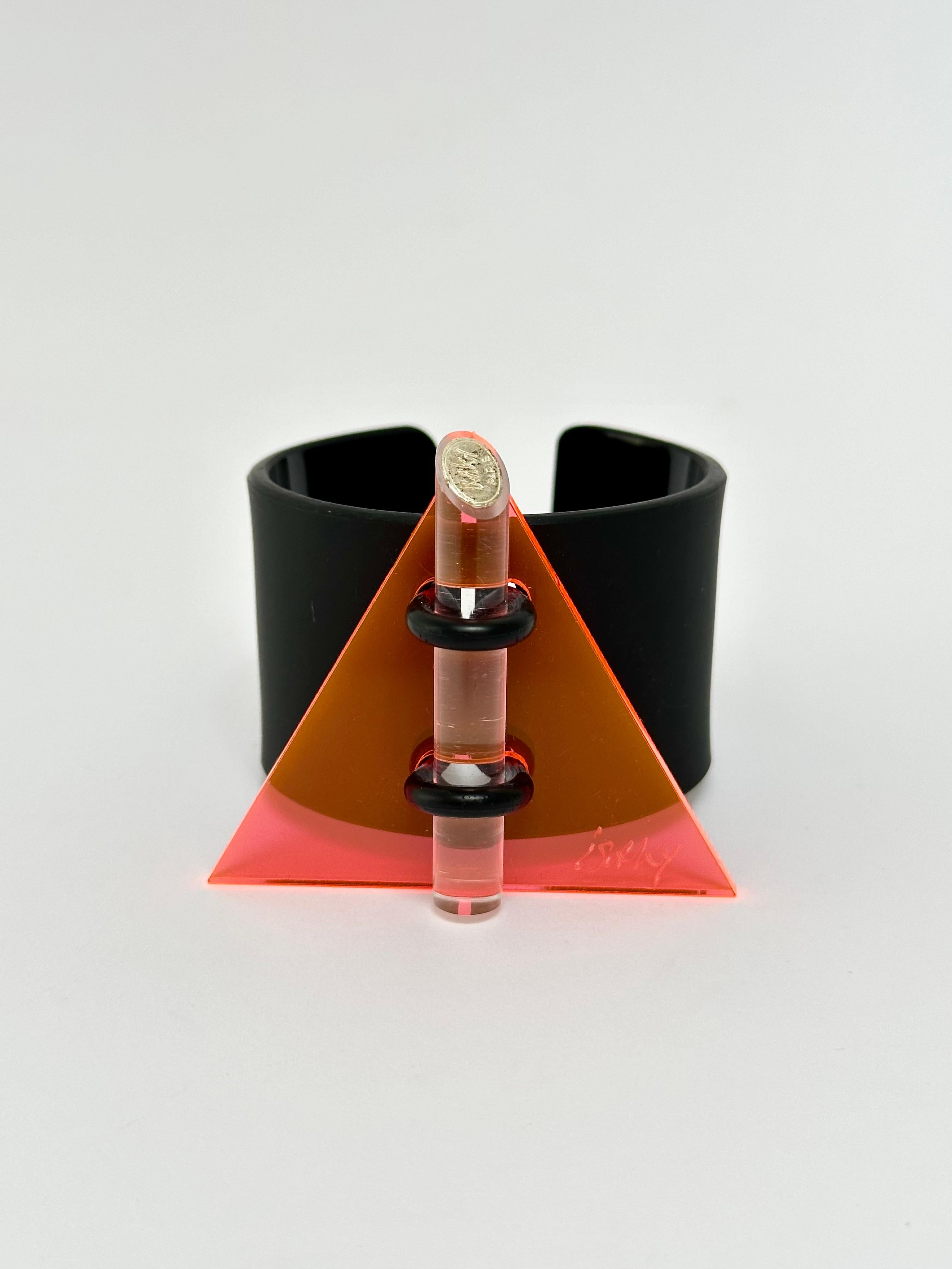 Methacrylate plate fixed by a rubber link on a black acrylic bracelet, matt exterior and glossy interior, locked by an altugas rod wearing the Artist's brand.

Both the facade and the bracelet are hand signed.

Measurements (cm) 
triangle's side