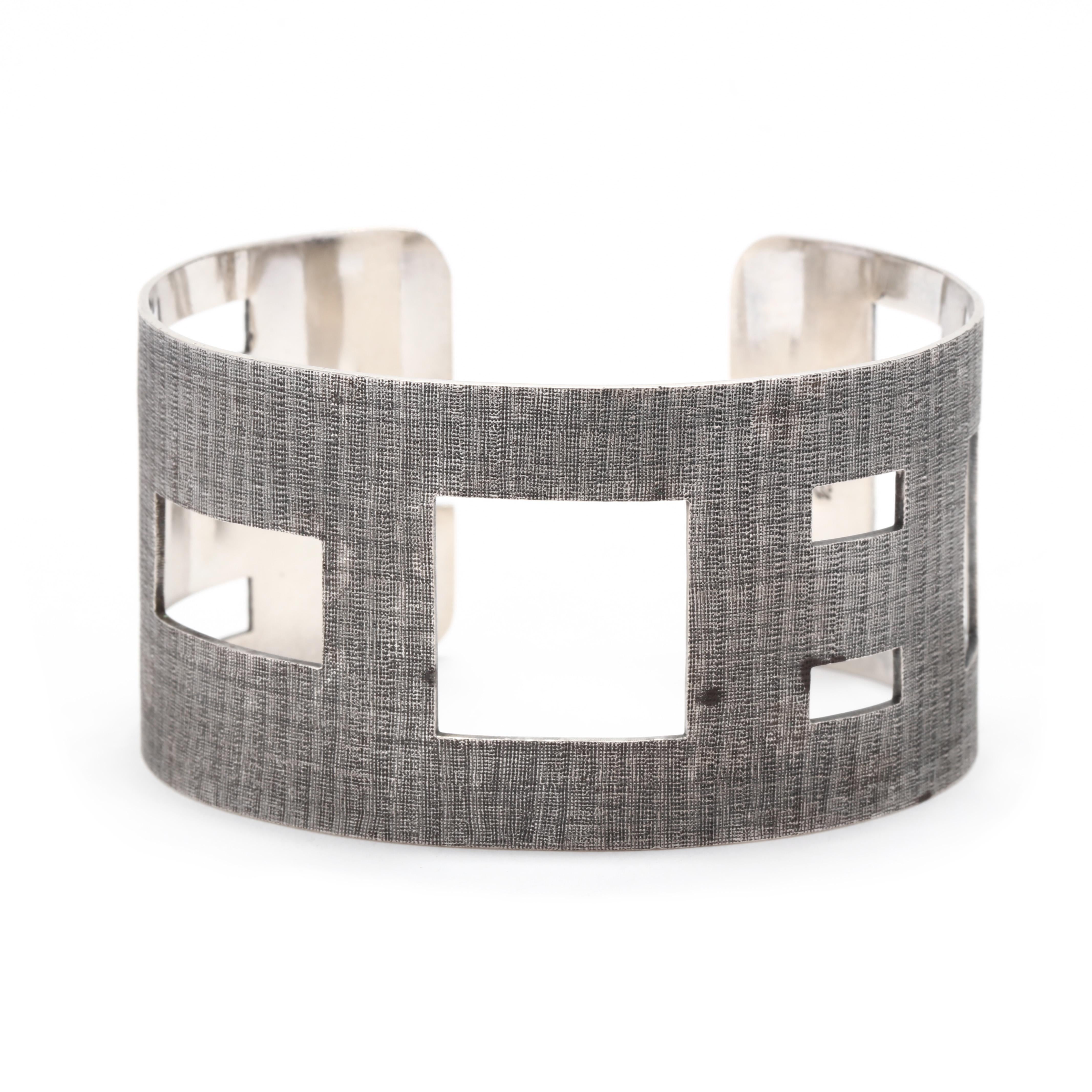 A vintage sterling silver geometric cut-out cuff bracelet.  This wide cuff bracelet features square and rectangular cut-outs of varying sizes, with a textured silver finish. It is stamped Sterling PS Diane.

Length: 7.5 inches with a 7.8 inch