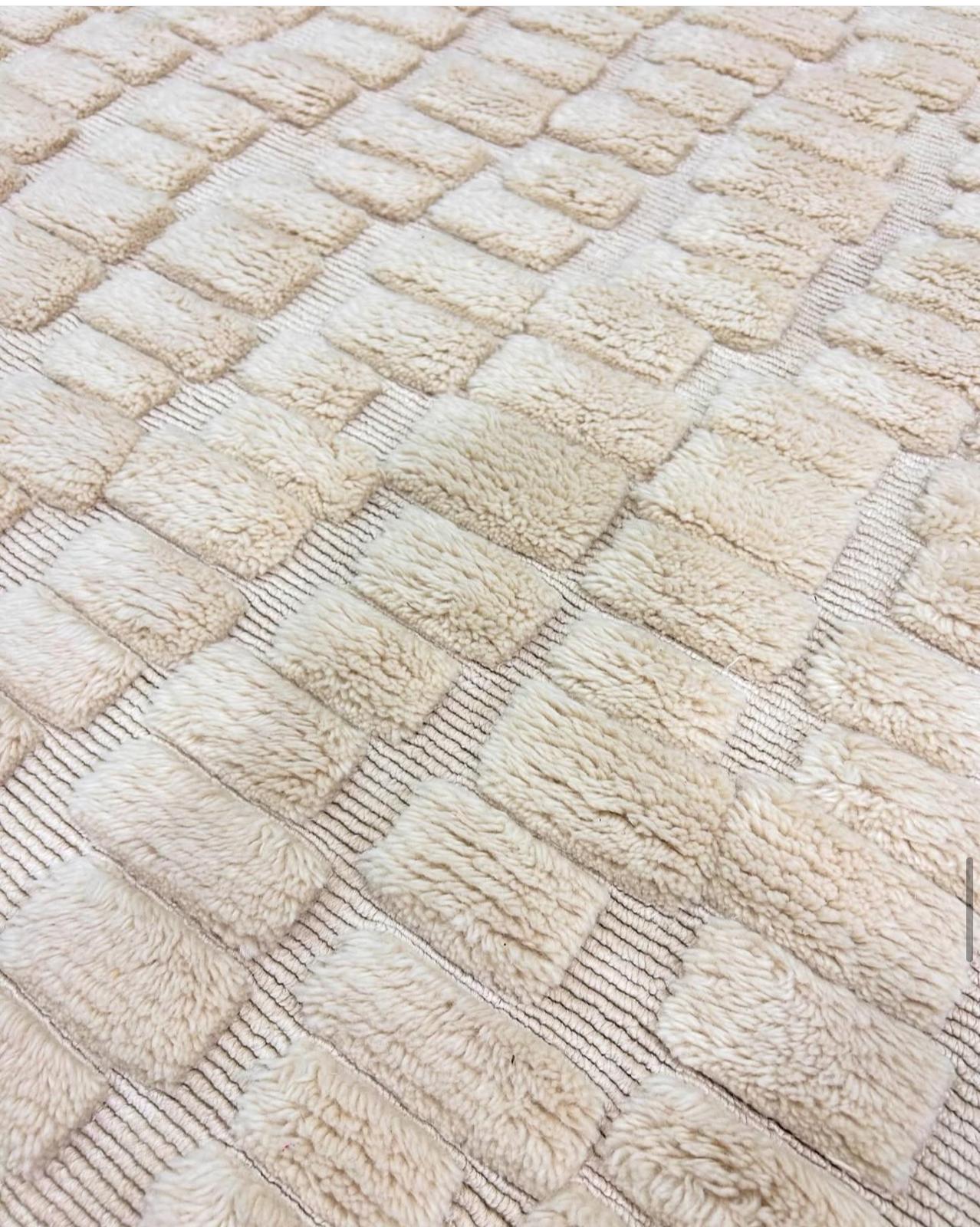 Eleva qualsiasi interno con questo tappeto Undulating Grid annodato a mano, un tessuto moderno e scultoreo realizzato in una raffinata miscela di lana tibetana e seta di bambù. La sua composizione fluida e ondulata trasforma una griglia classica in