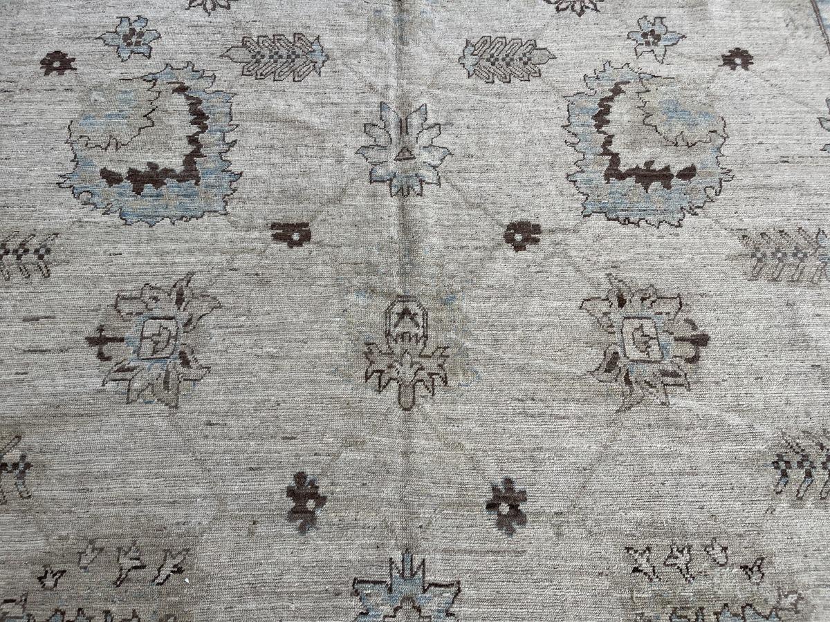 This All-Over Khotan design is a transitional take on a rug design that has been in use for centuries. Neat rows of  square shaped designs framed by a stunning intricately woven pattern that is finished with an exquisitely complementary border that
