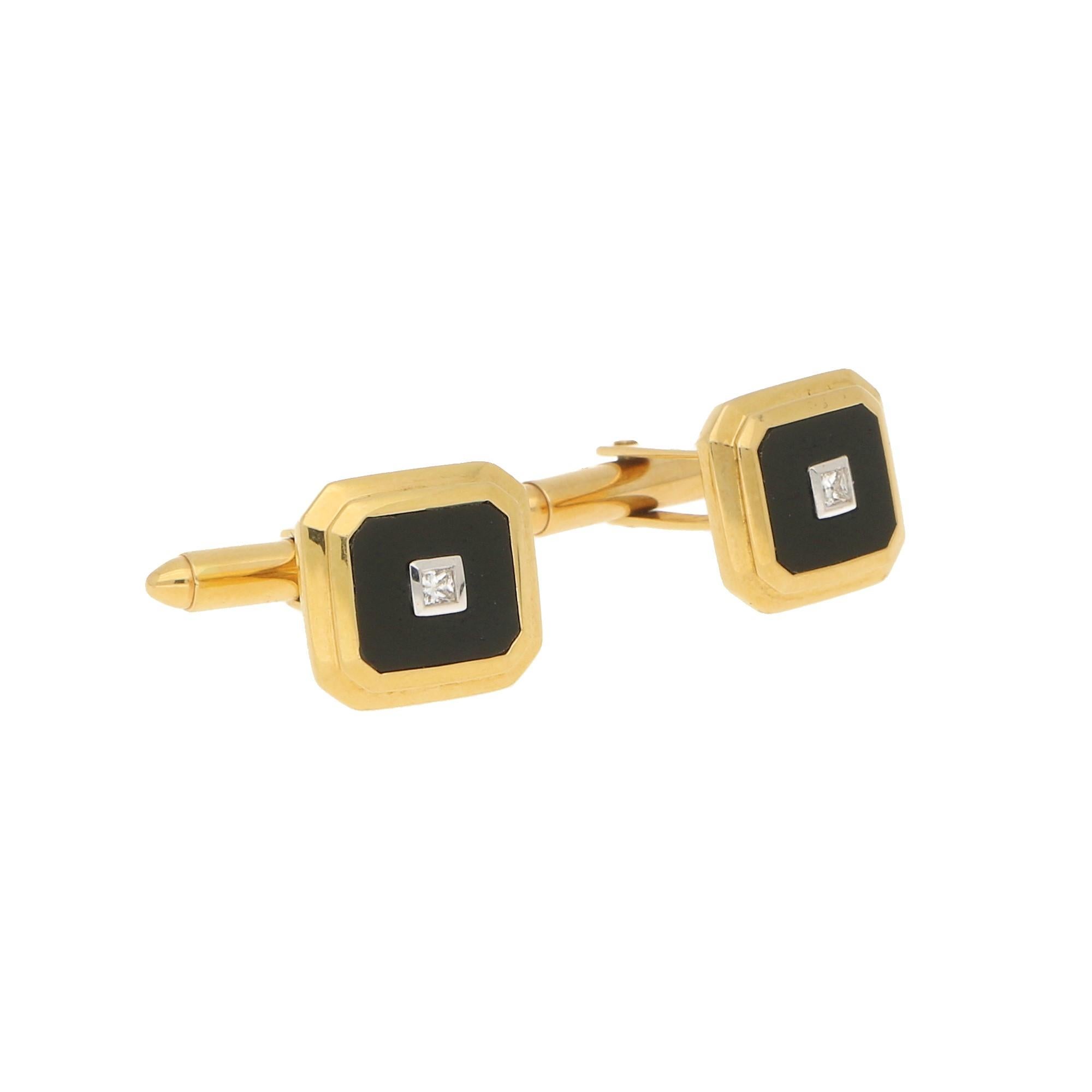 A pair of diamond and onyx geometric cufflinks in 18-karat yellow gold.  Each cufflink features an octagonal tiered plaque in yellow gold, and an onyx plaque at it's center, which in turn is further accented with a princess-cut diamond in a white