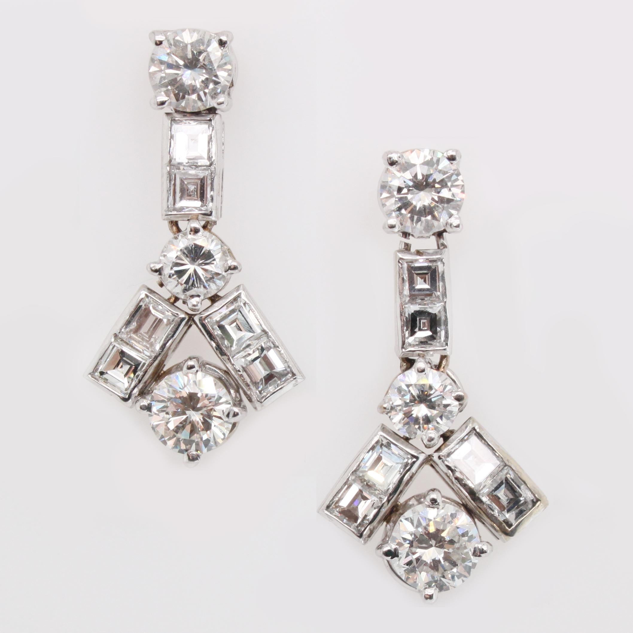 Geometric diamond round solitaire and diamond square cut earrings in 18k white gold. The diamonds weigh approximately 4-4.5 carats in total and are of very fine quality. The bottom half of the earrings move and are flexible.
