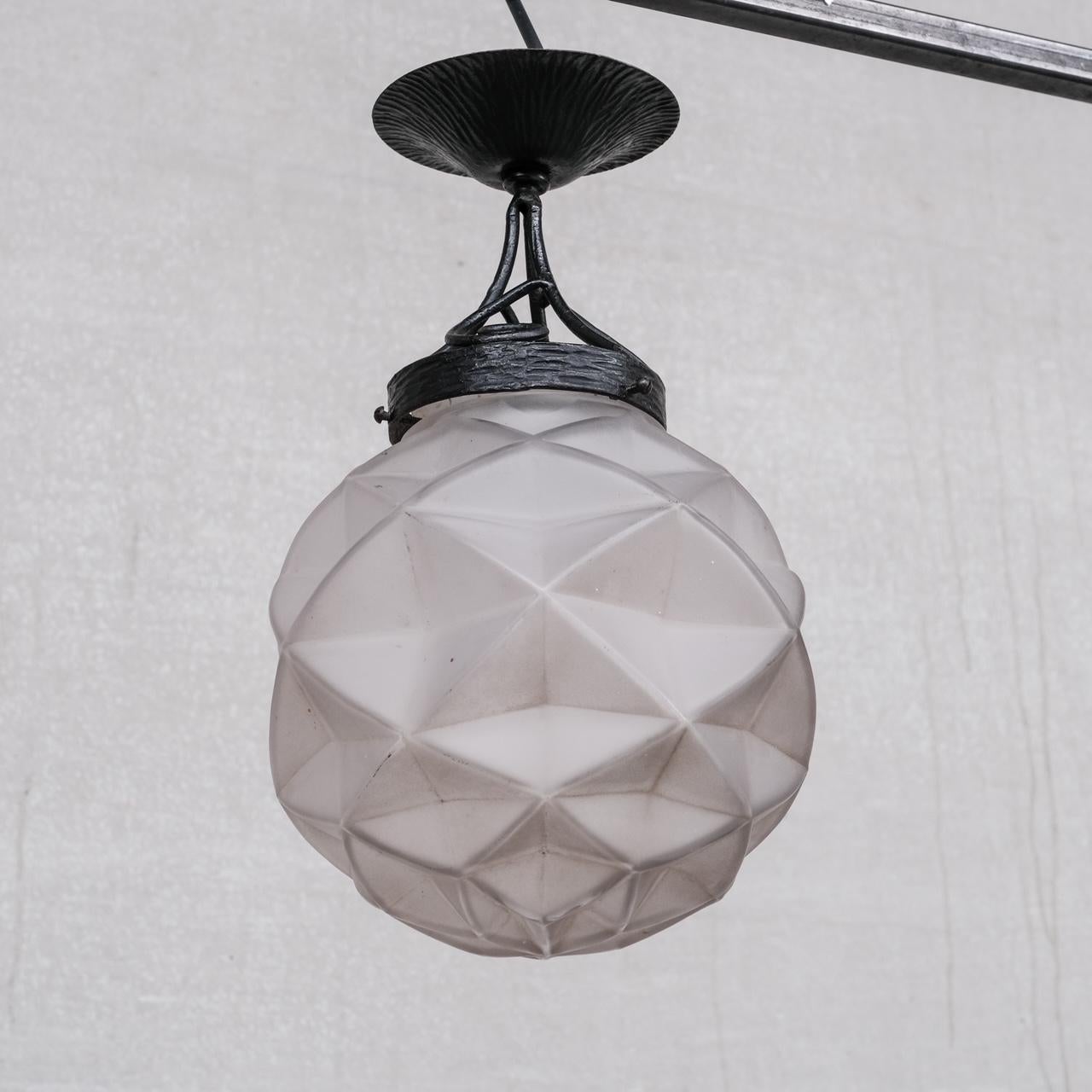 A stylish iron and glass pendant light. 

France, c1950s. 

A geometric style moulded glass shade of unusual rare form. 

Since re-wired and PAT tested. 

Good condition. 

Location: Belgium Gallery. 

Dimensions: 23 Diameter 37 Height