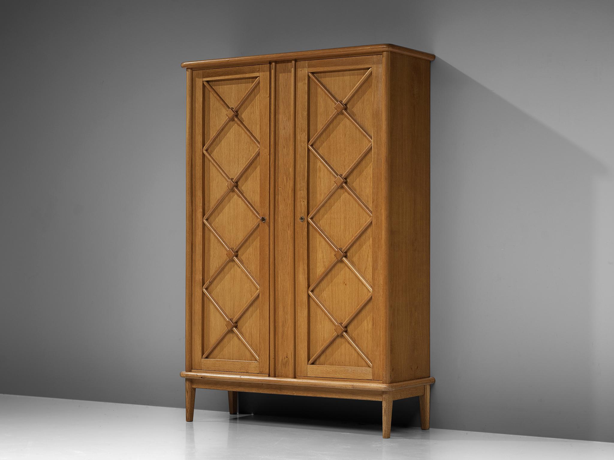 High board, oak, France, 1960s

An elegant case piece in oak that features geometric details in the doors. The high board is lifted from the ground by slim, conical legs that give the solid looking body a more airy appearance. The cabinet with